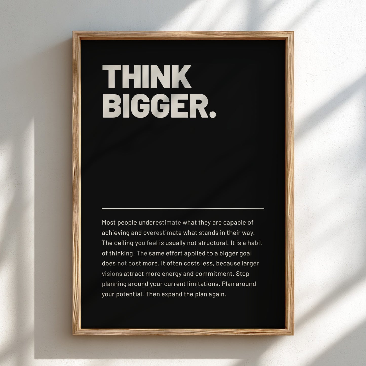 Framed poster with 'Think Bigger' text on a black background