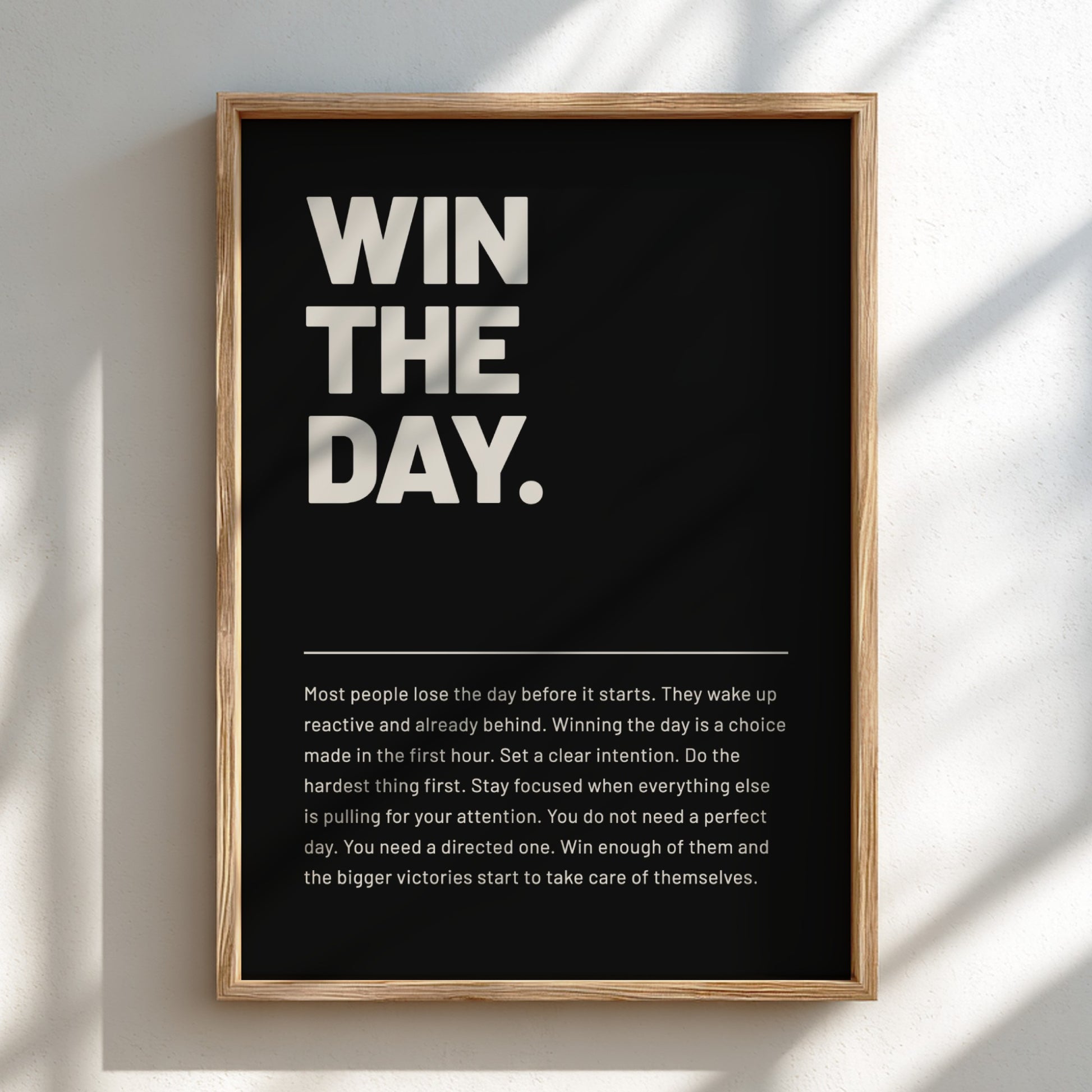 Framed poster with motivational text 'WIN THE DAY.' on a black background