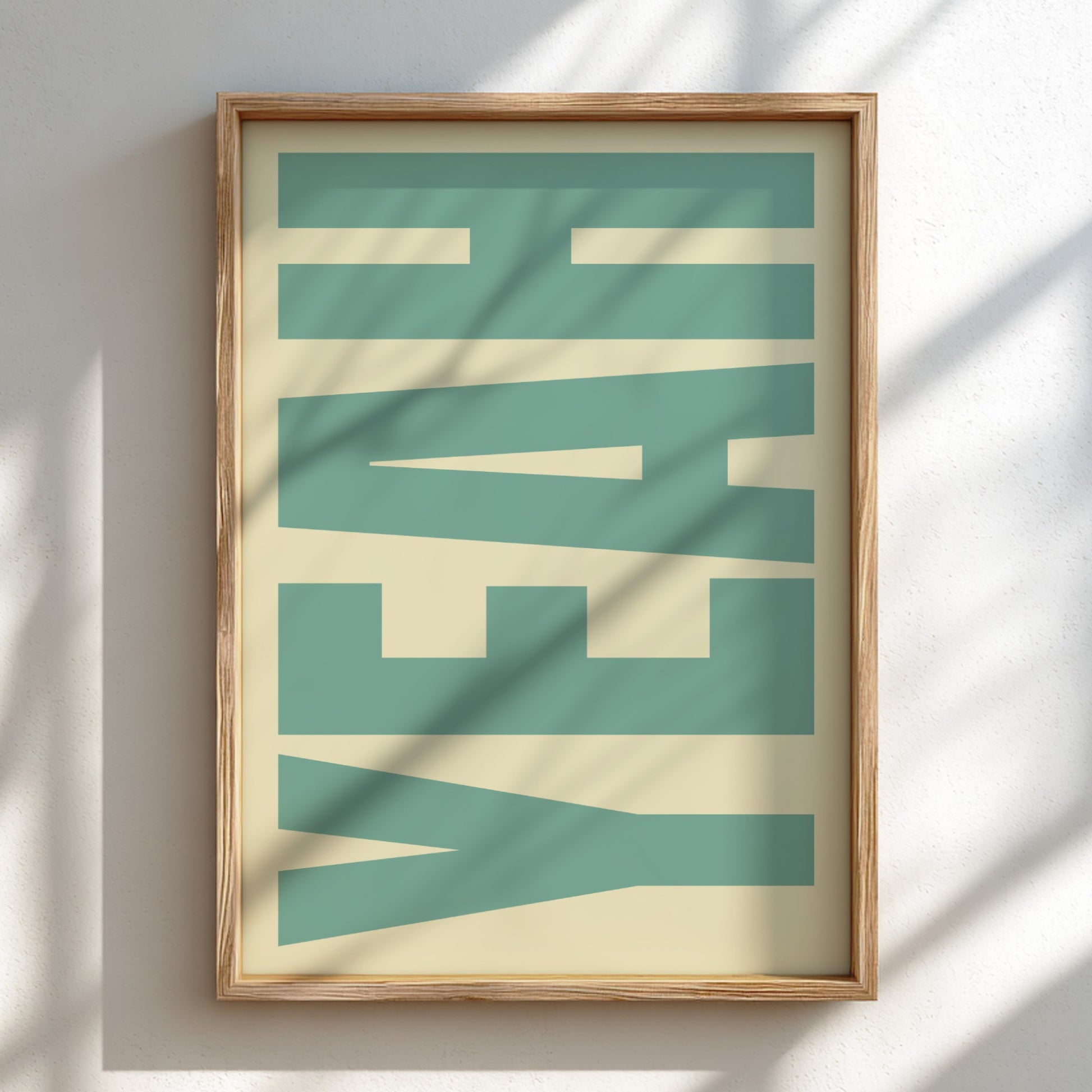 Framed artwork with 'YEAH' in green and beige on a white wall