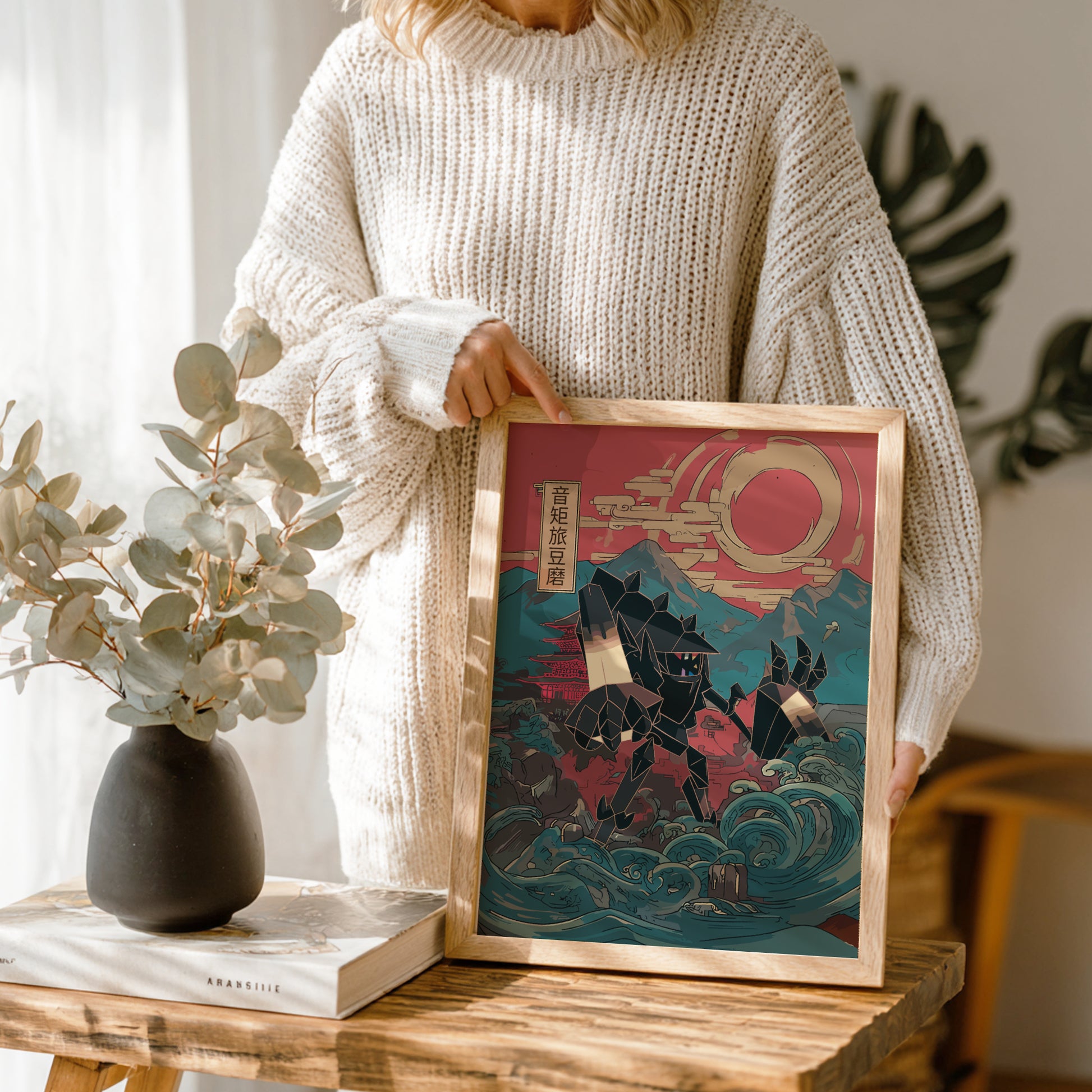 Person holding a framed artwork with a stylized design Necrozma Pokemon, set against a mountain and wave background.