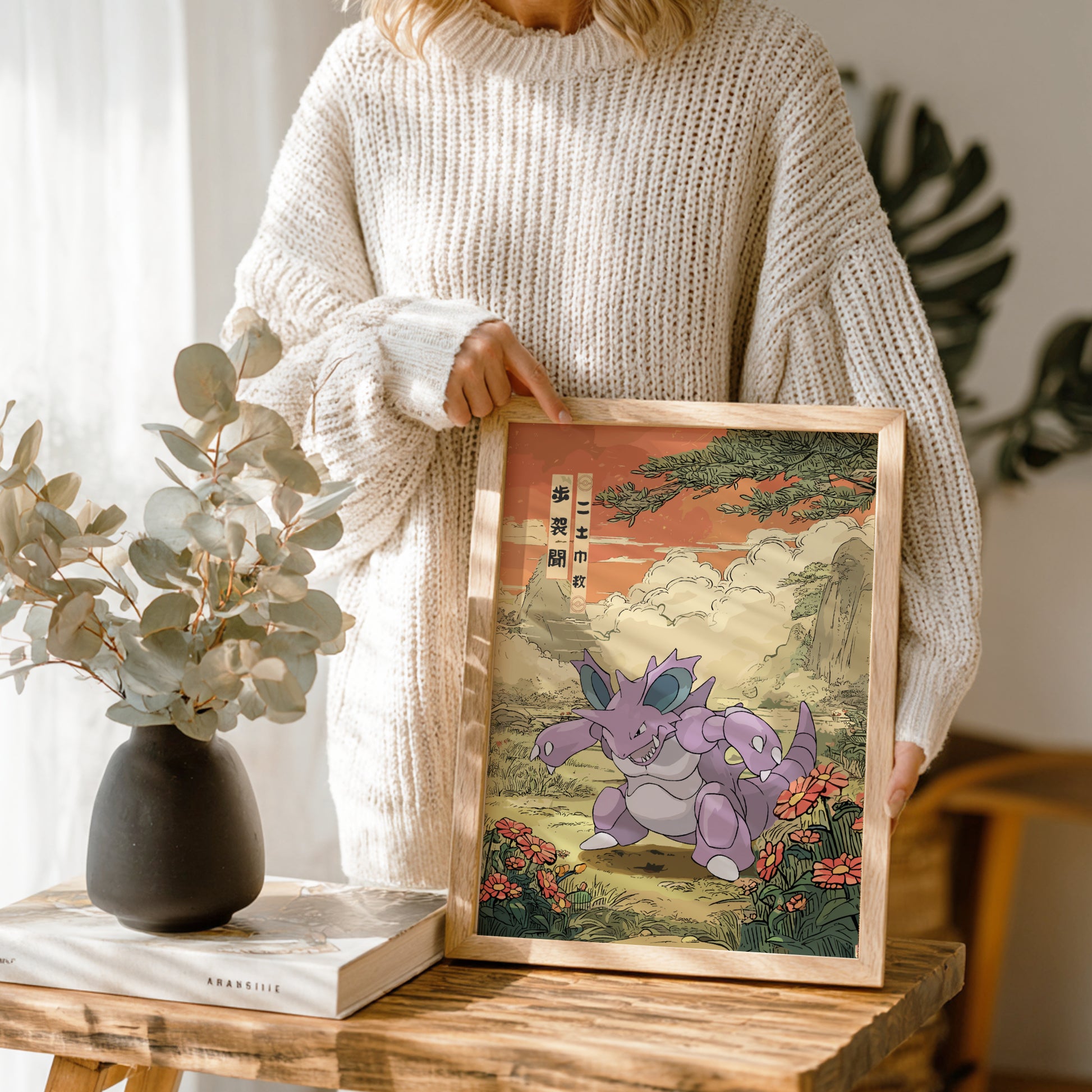 Person holding a framed artwork of Nidoking Pokemon in a natural setting