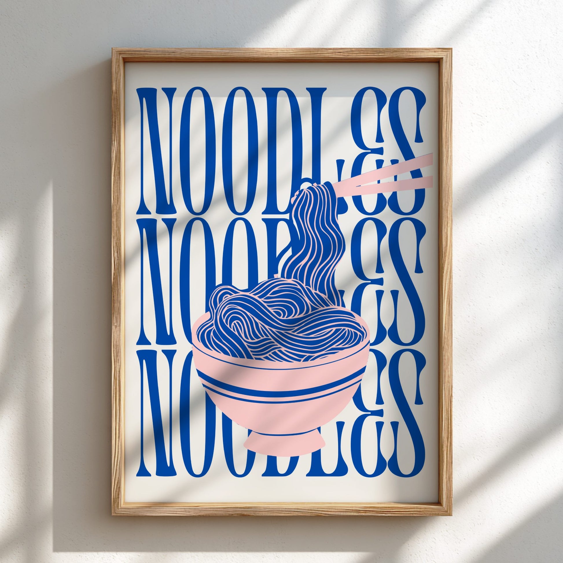 Framed artwork with blue text and illustration of noodles on a white wall.