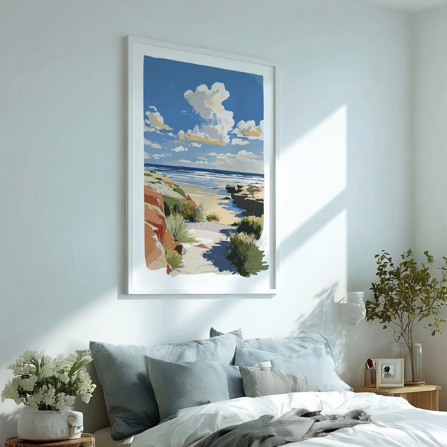Framed beach artwork above a bed in a bright bedroom