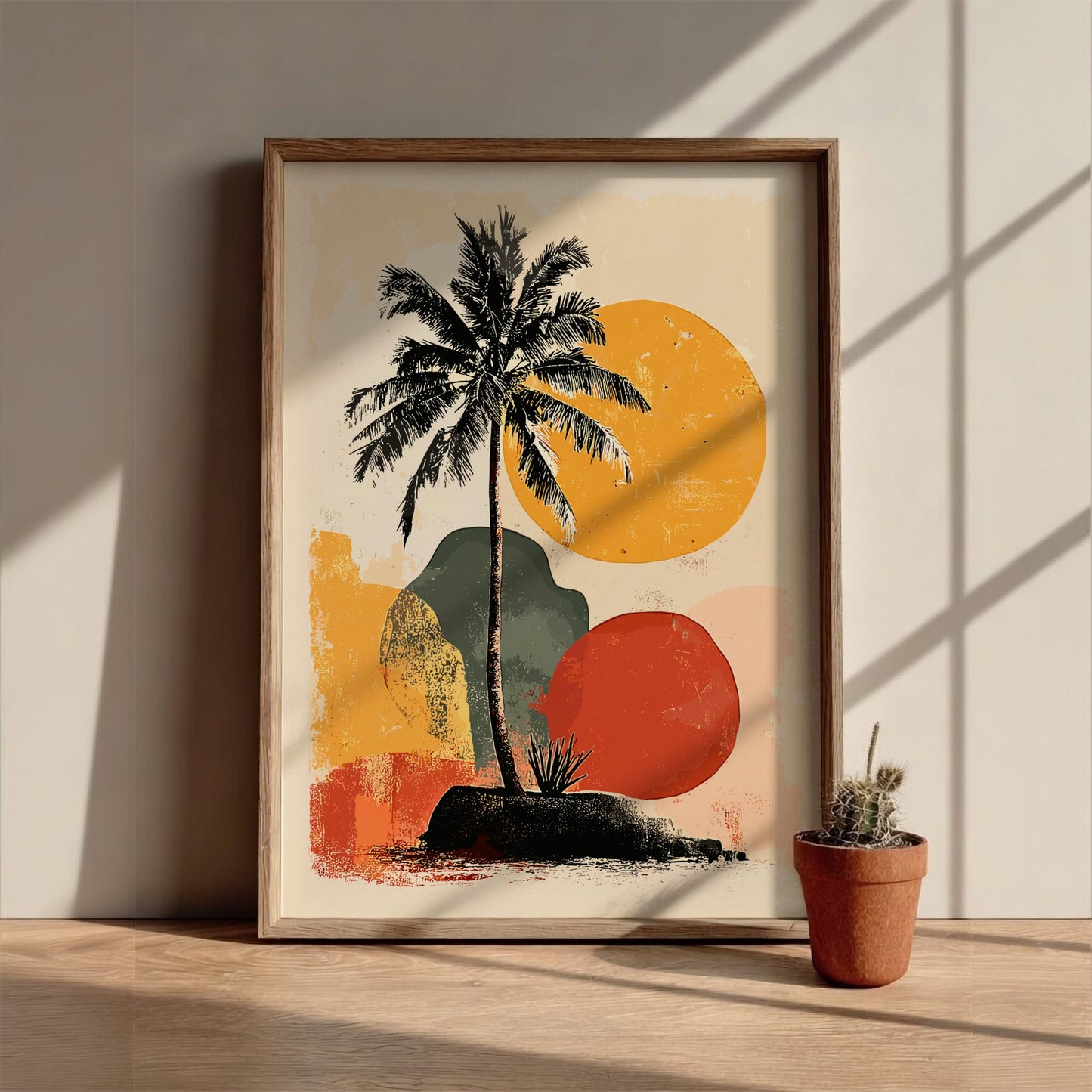 Framed artwork with a palm tree and abstract shapes on a wooden surface.