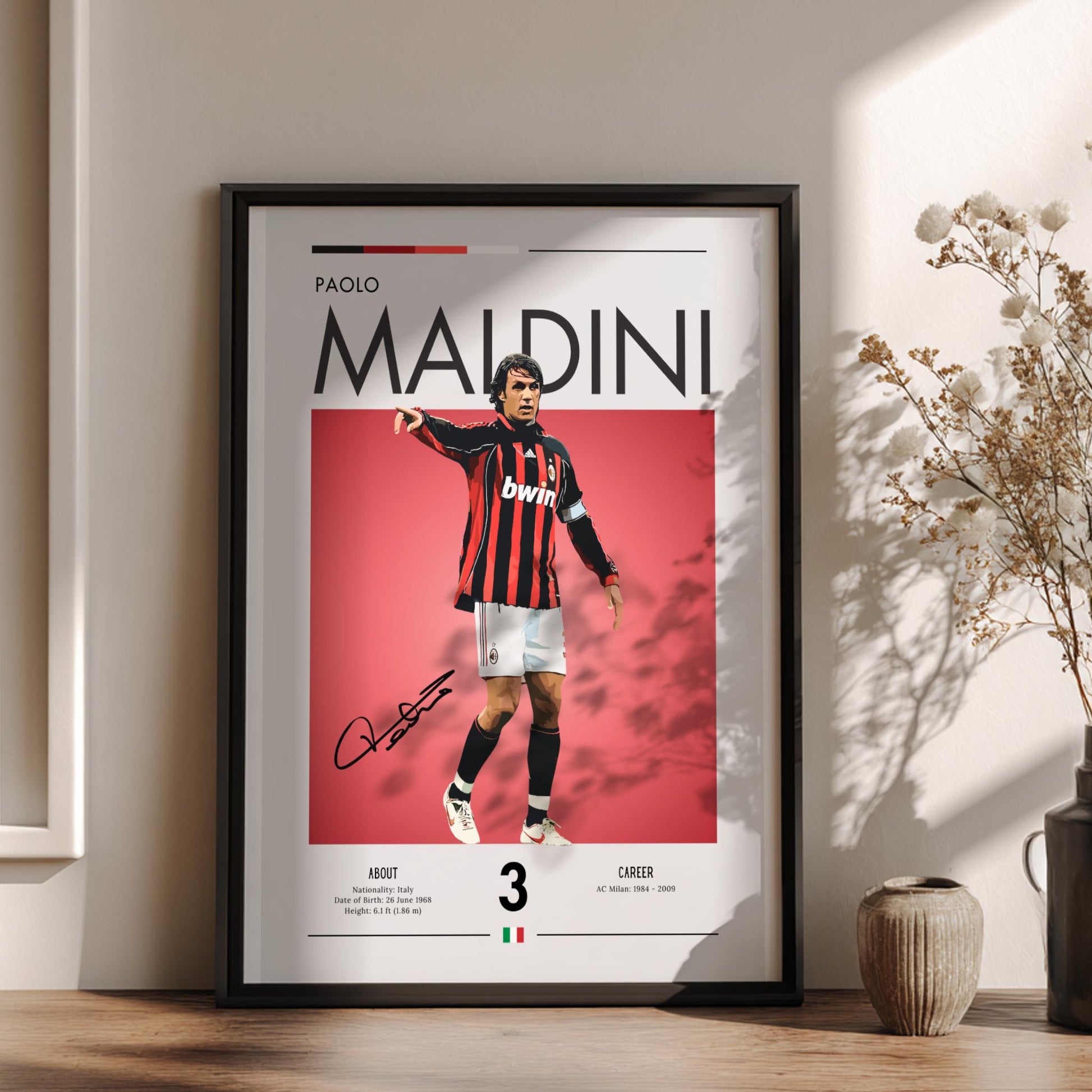 Framed poster of Paolo Maldini in a sports jersey on a wall with decorative elements.