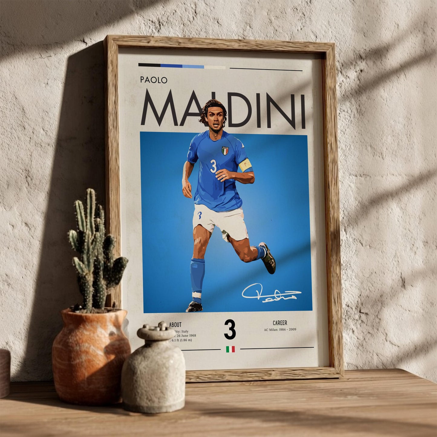 Framed poster of Paolo Maldini in a blue jersey with a cactus and decorative pot in the background.
