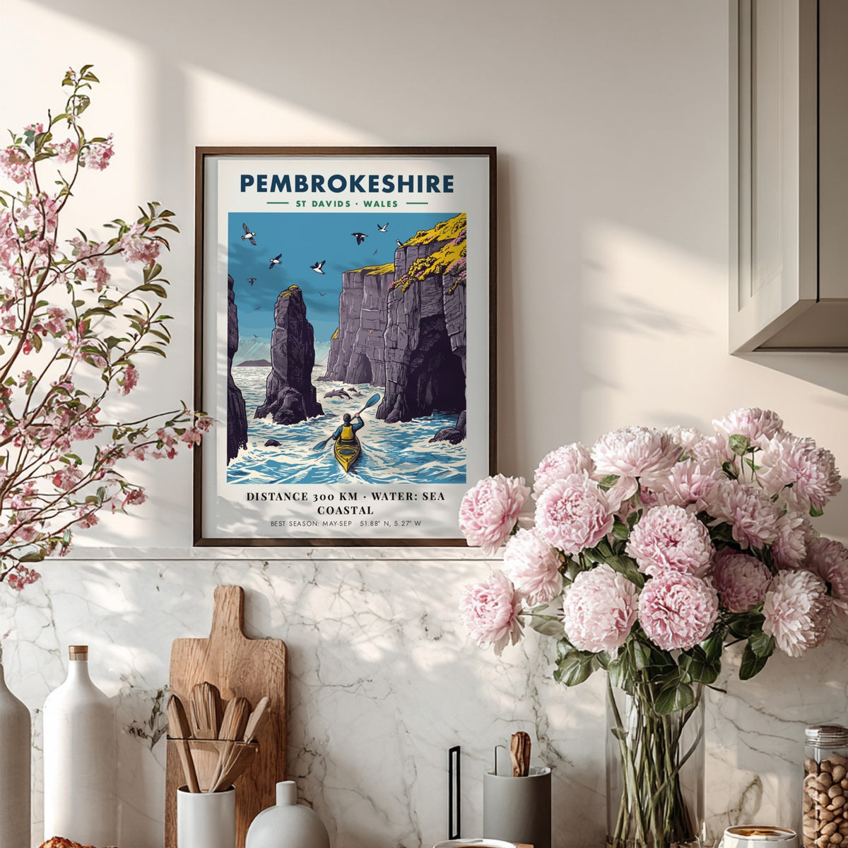 Poster featuring a kayaker paddling near tall Pembrokeshire sea cliffs with blue water.