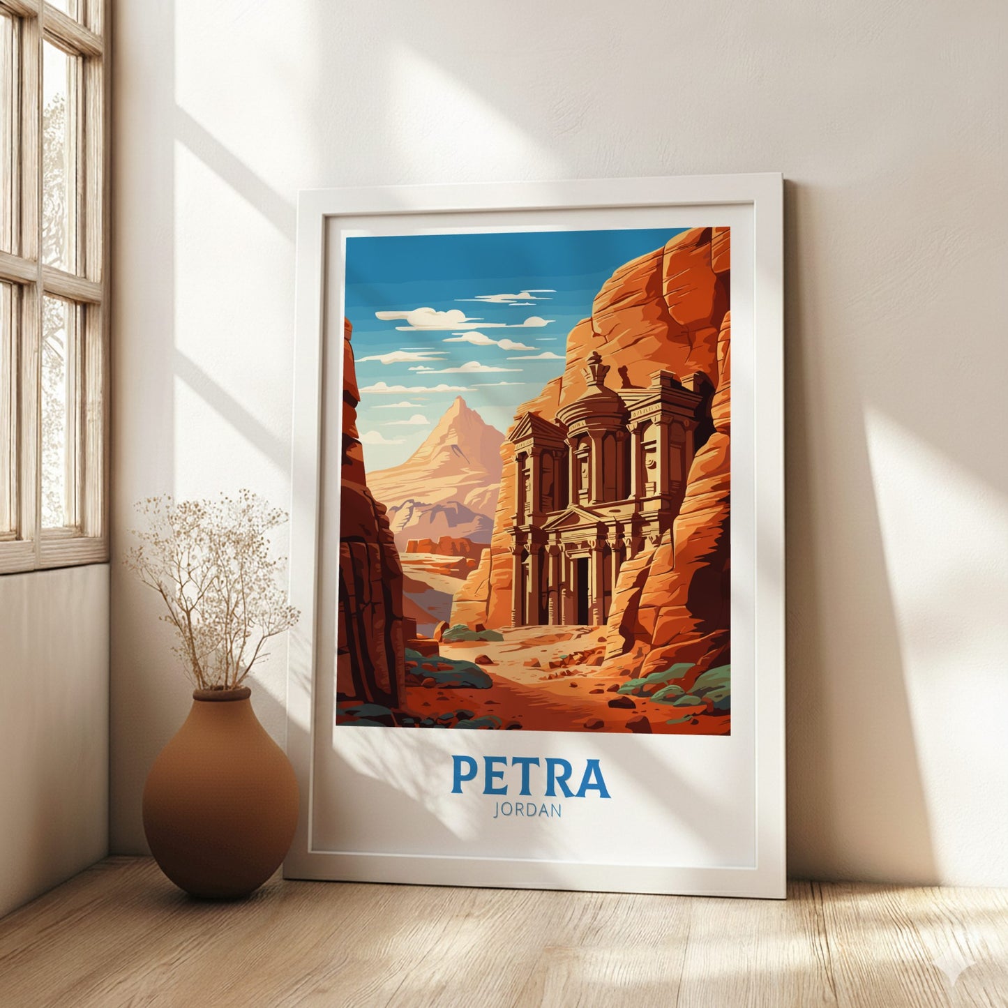 Framed poster of Petra, Jordan in a room with a vase and window.