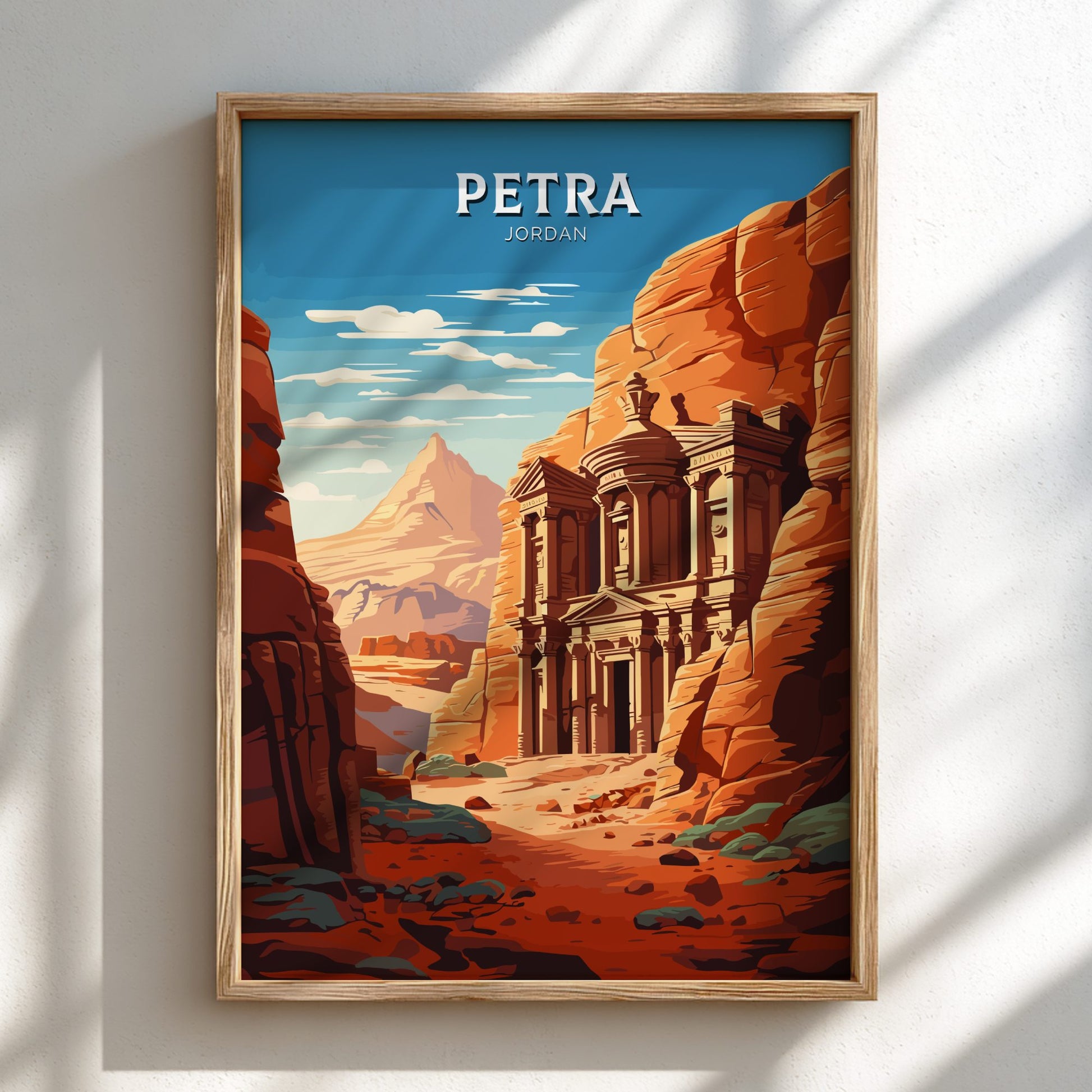 Framed poster of Petra, Jordan with a wooden frame on a white wall.
