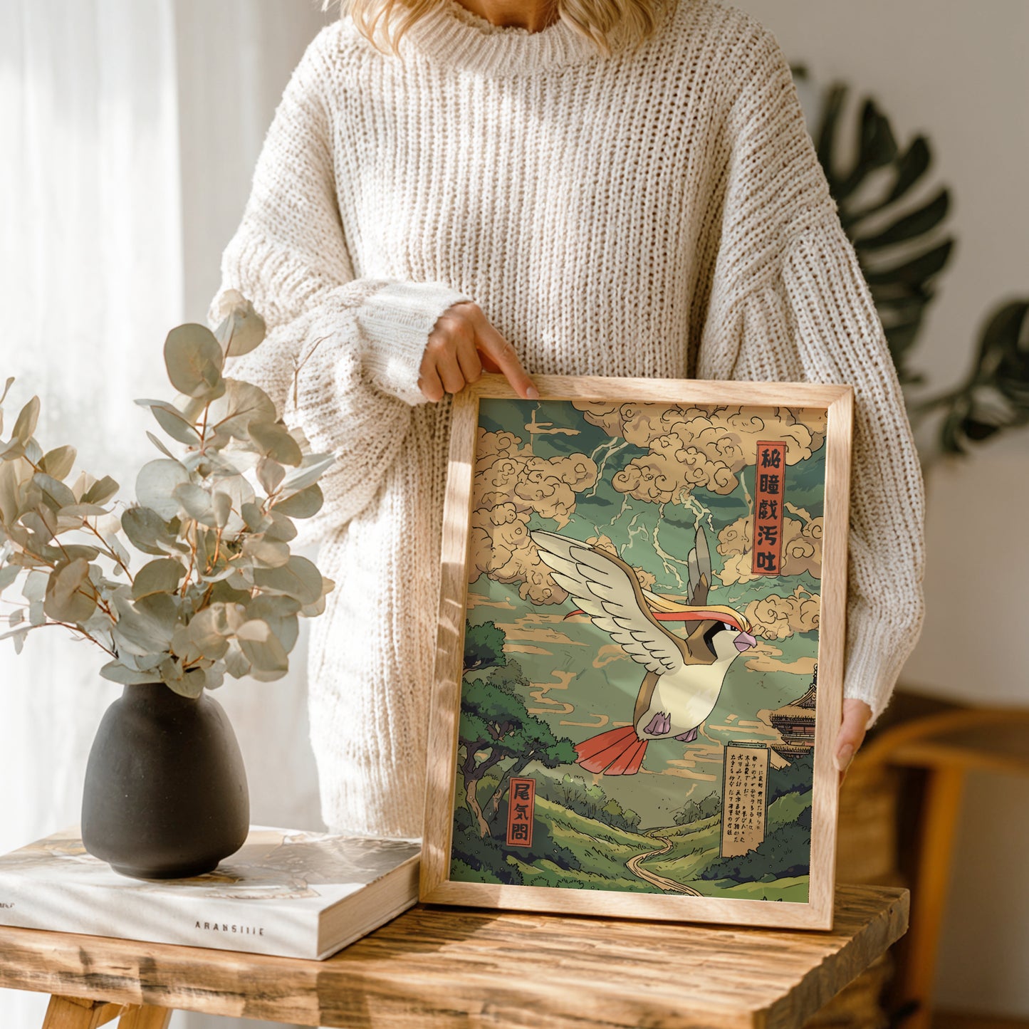 Person holding a framed artwork of Pidgeot Pokemon in a natural setting