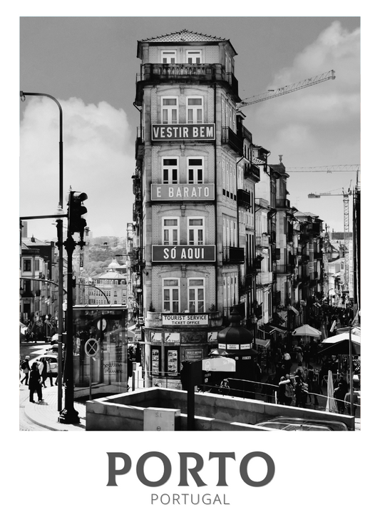 Black and white street scene in Porto, Portugal with a tall building featuring signage.