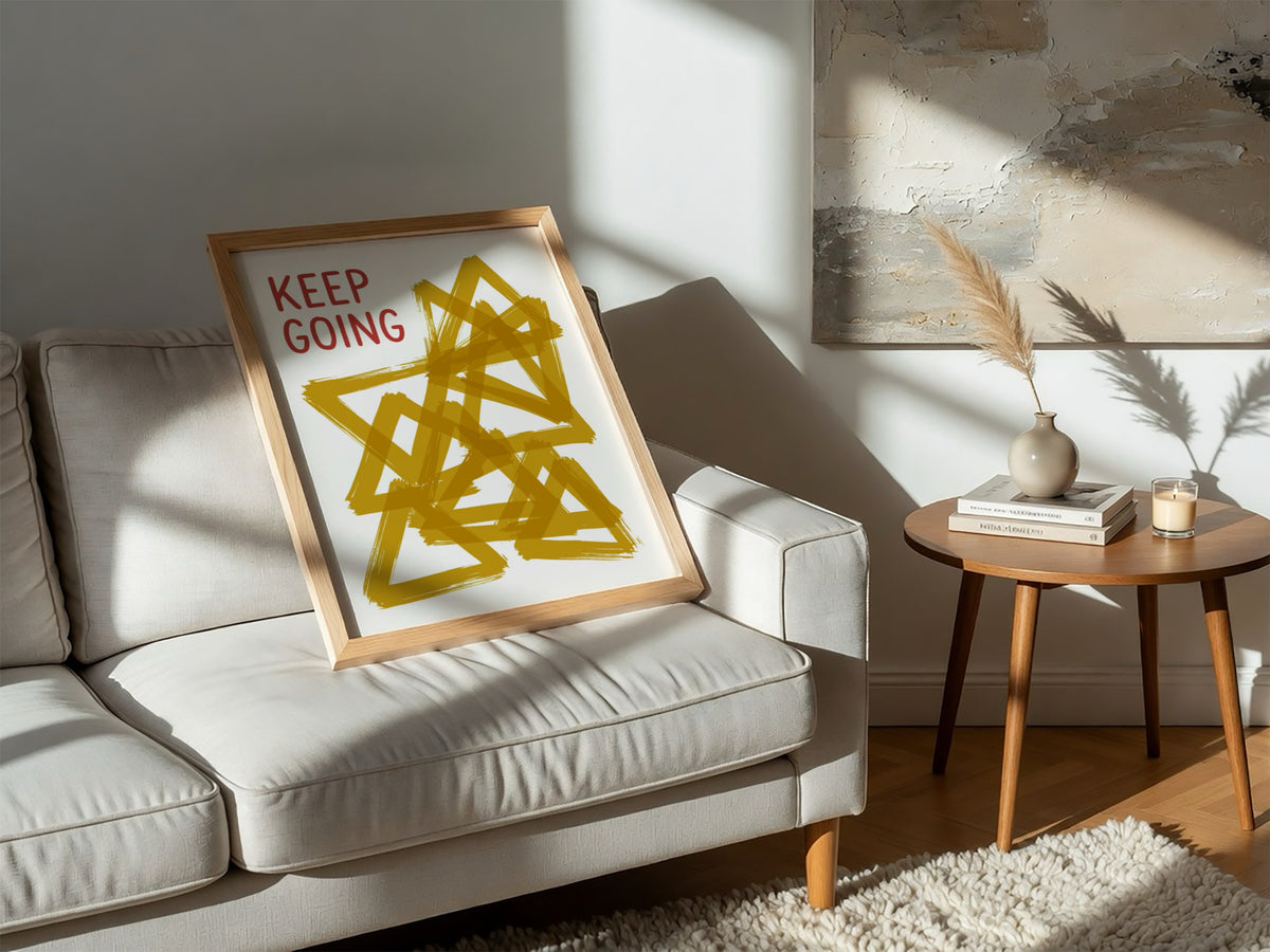 Motivational poster featuring the text Keep Going alongside abstract overlapping mustard yellow triangles.