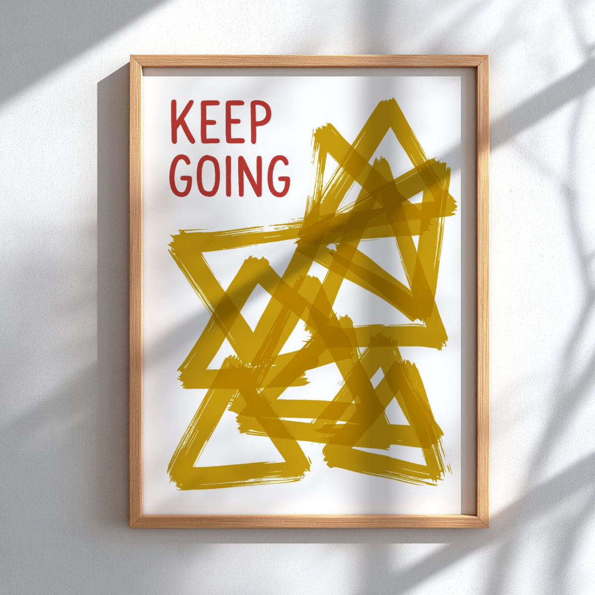 Motivational poster featuring the text Keep Going alongside abstract overlapping mustard yellow triangles.