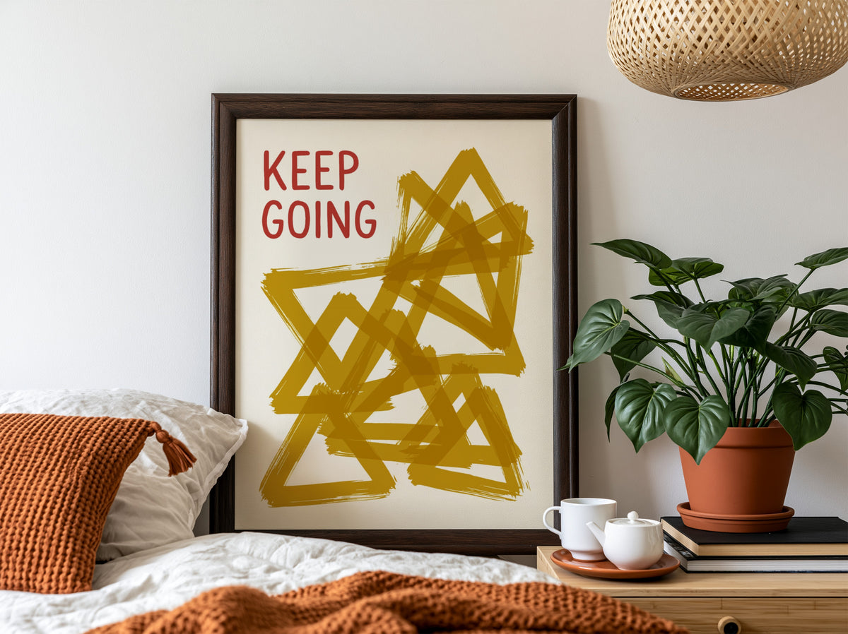 Motivational poster featuring the text Keep Going alongside abstract overlapping mustard yellow triangles.