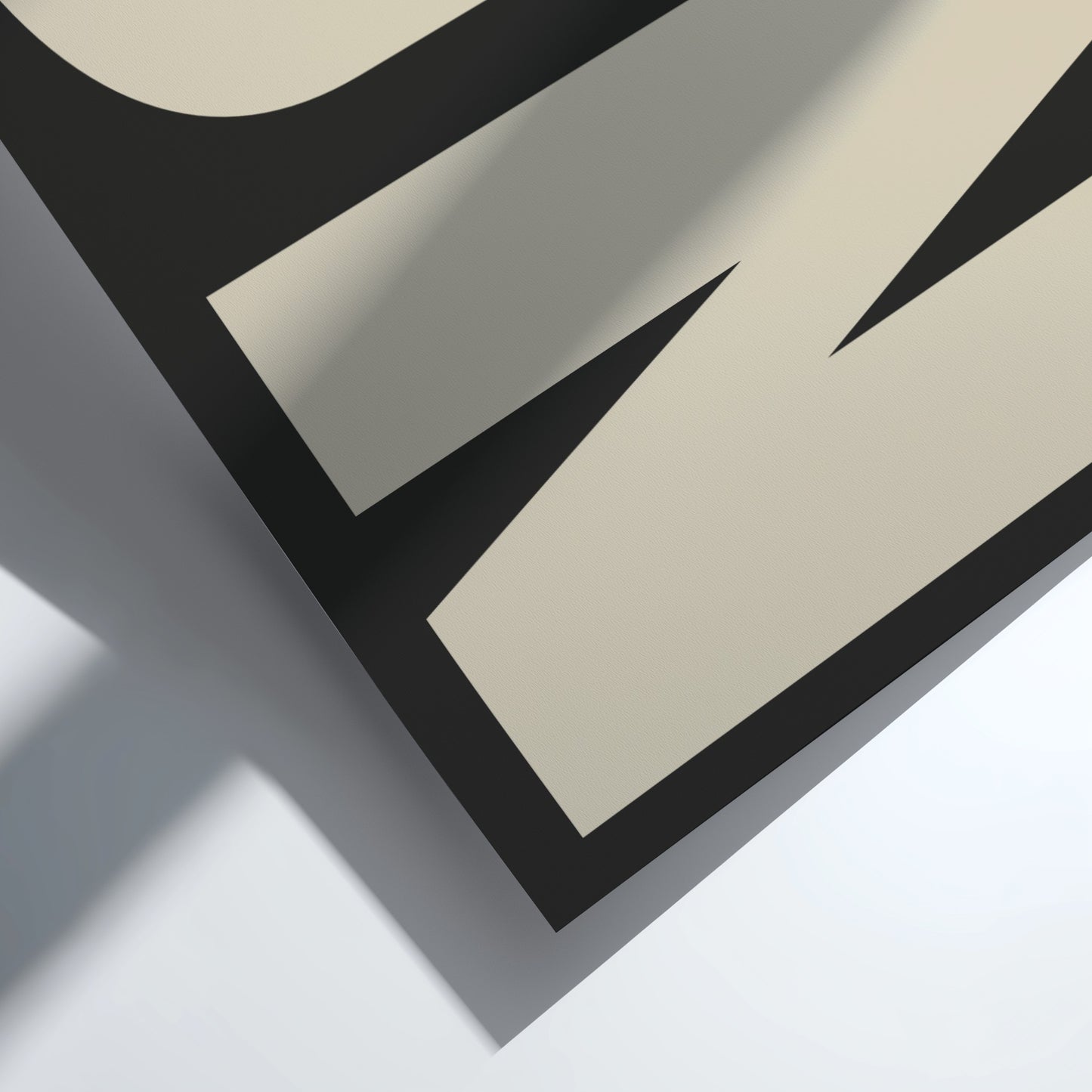 Close-up of a geometric design with black and beige shapes on a light gray background