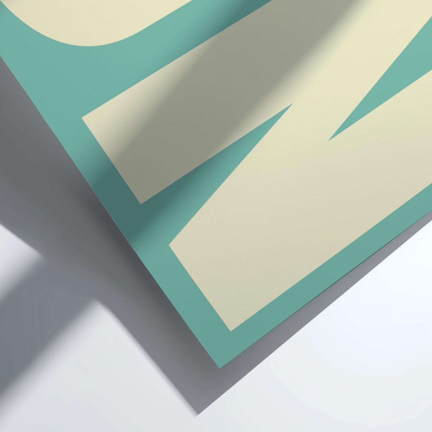 Close-up of a folded paper with teal and beige colors on a white background