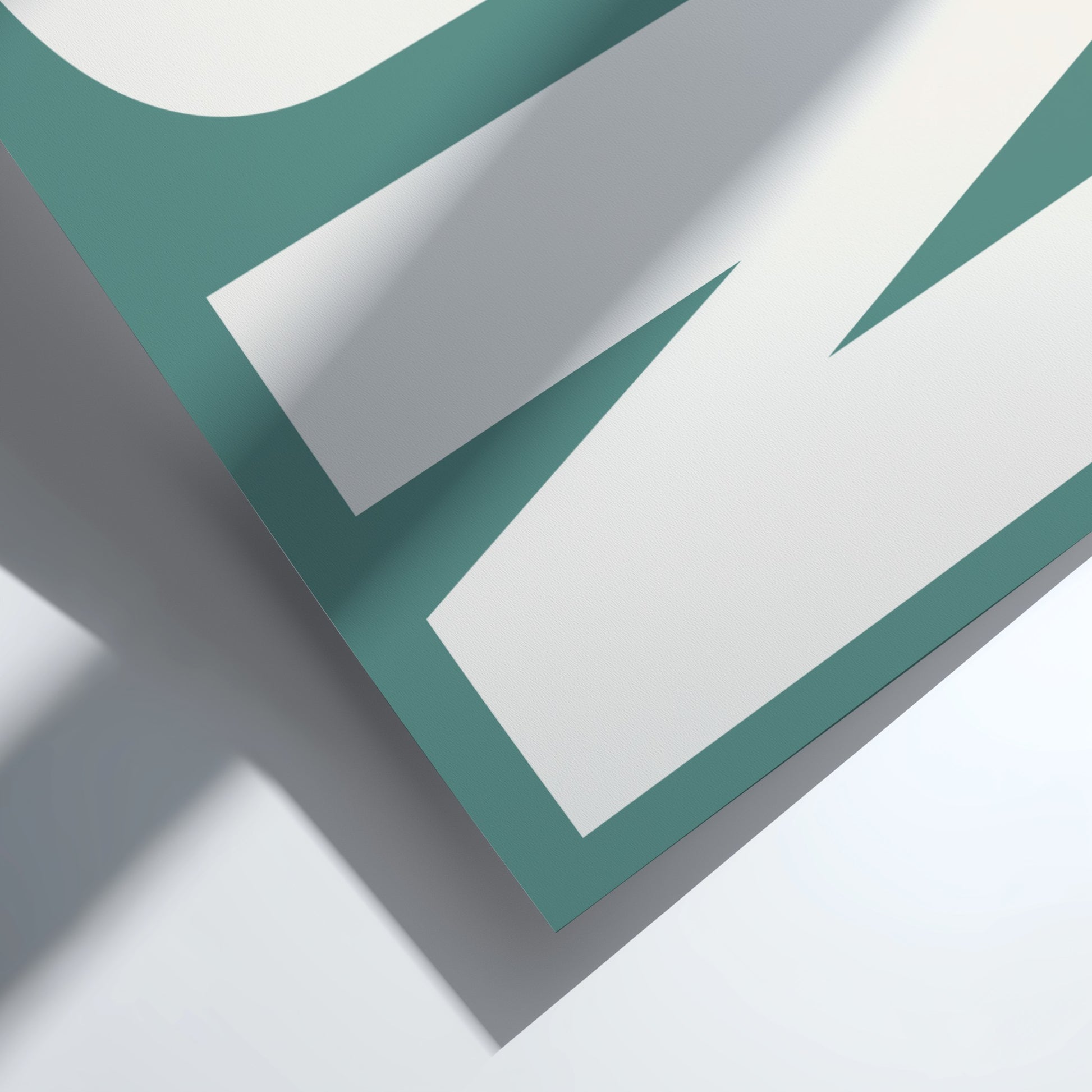 Close-up of a teal and white geometric design on a light gray background