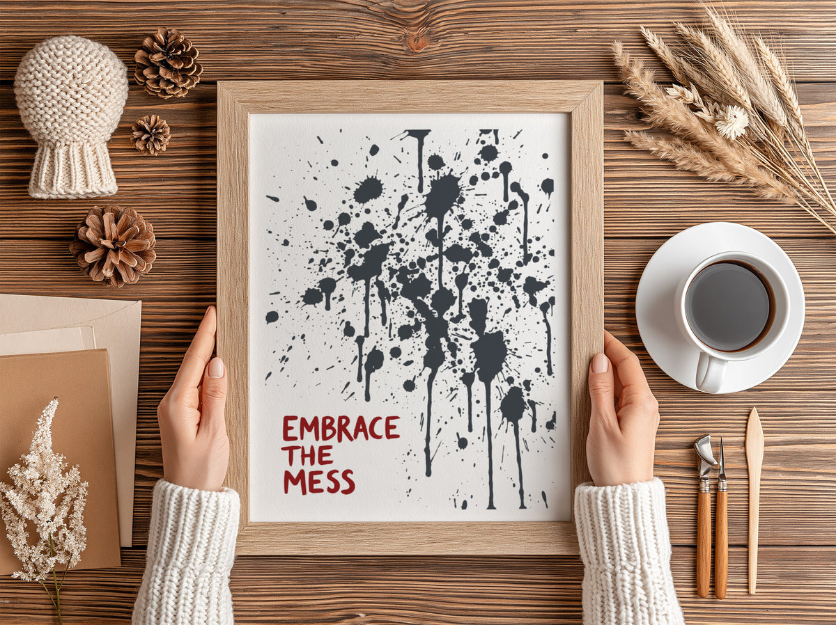 Motivational poster featuring Embrace The Mess text with abstract black ink splatter design