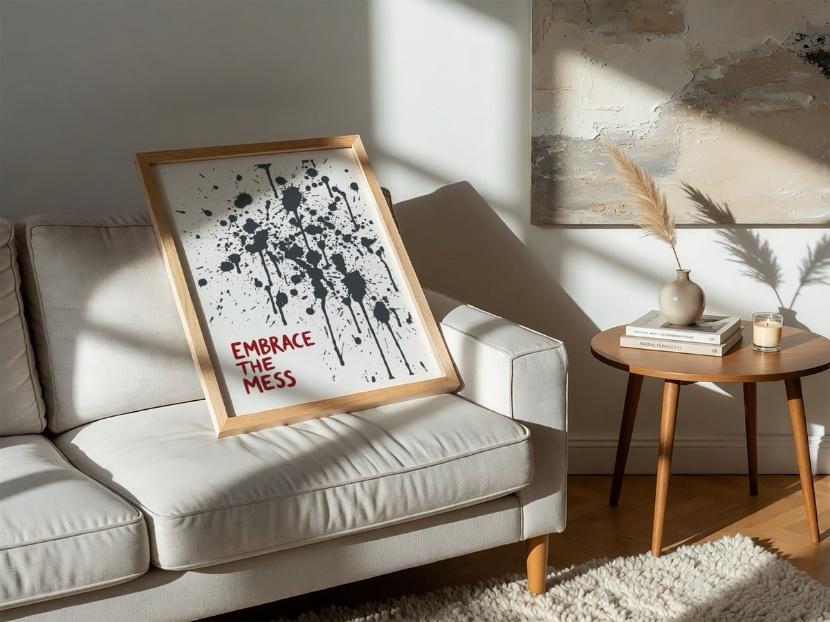 Motivational poster featuring Embrace The Mess text with abstract black ink splatter design