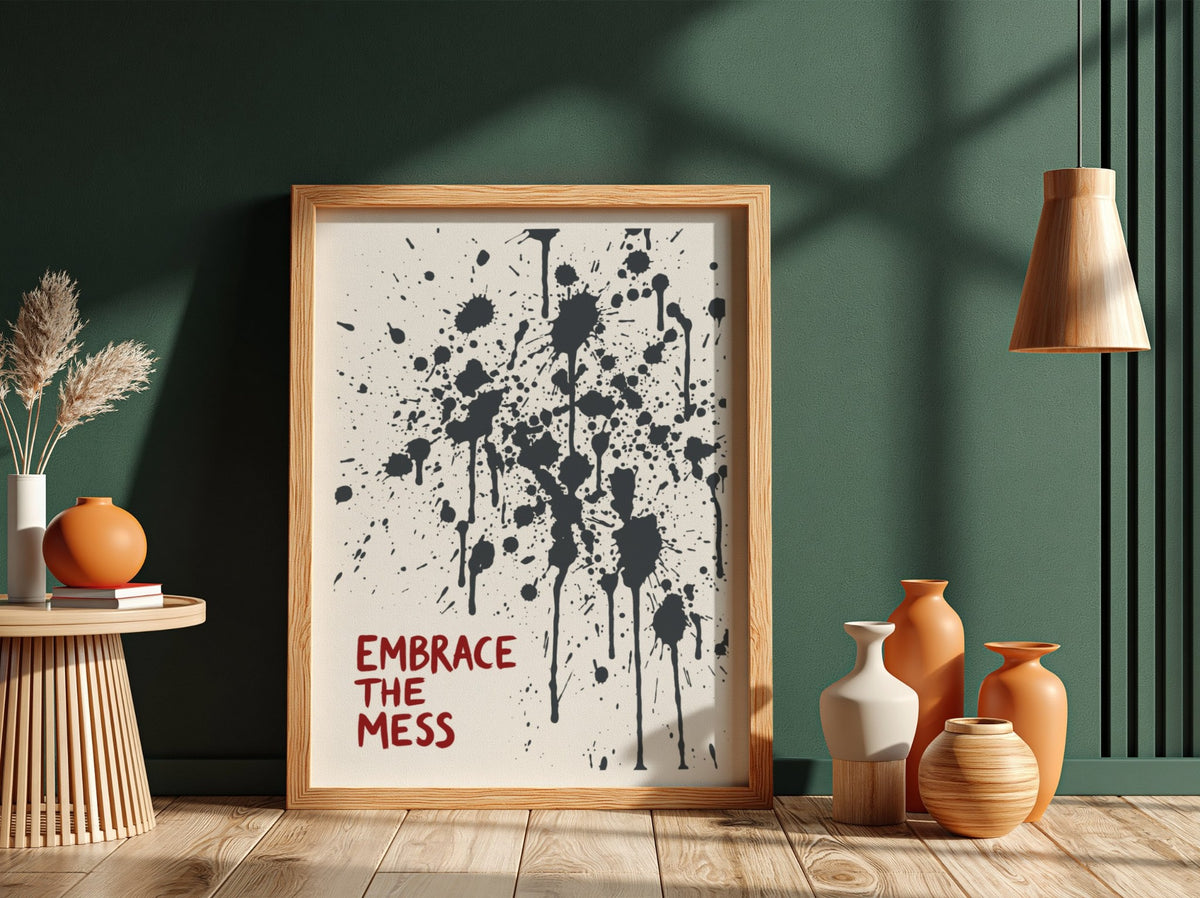 Motivational poster featuring Embrace The Mess text with abstract black ink splatter design