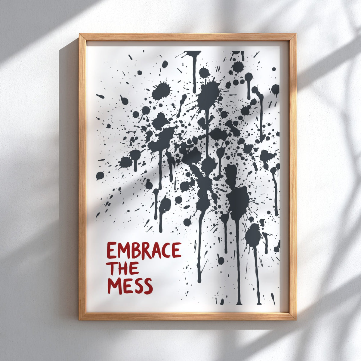 Motivational poster featuring Embrace The Mess text with abstract black ink splatter design