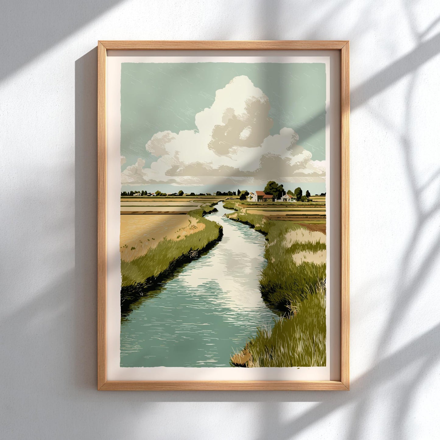 Framed artwork of a landscape with a river and clouds on a white wall.