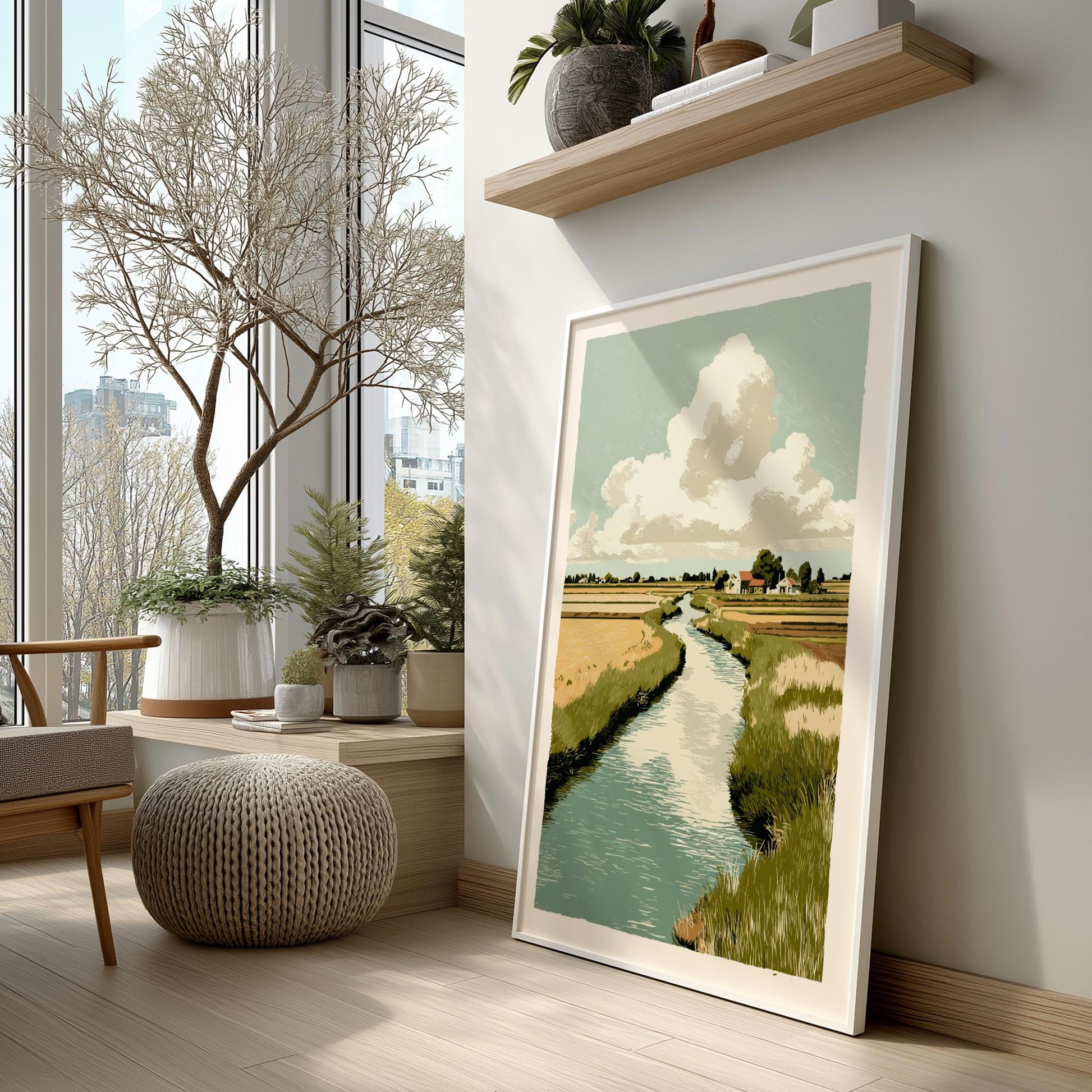 Framed landscape print on a wall in a room with large windows and indoor plants.