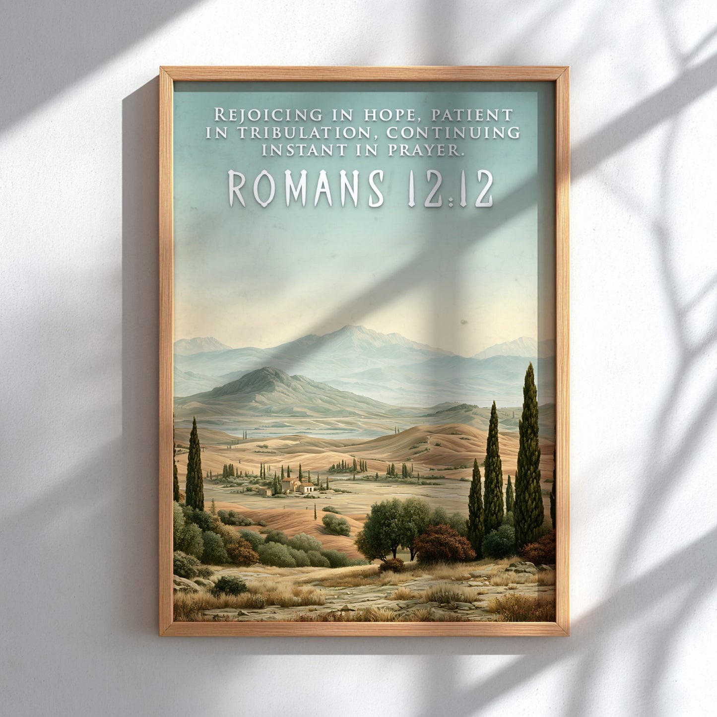 Poster displaying the Romans 12:12 quote over a scenic landscape of rolling golden hills.