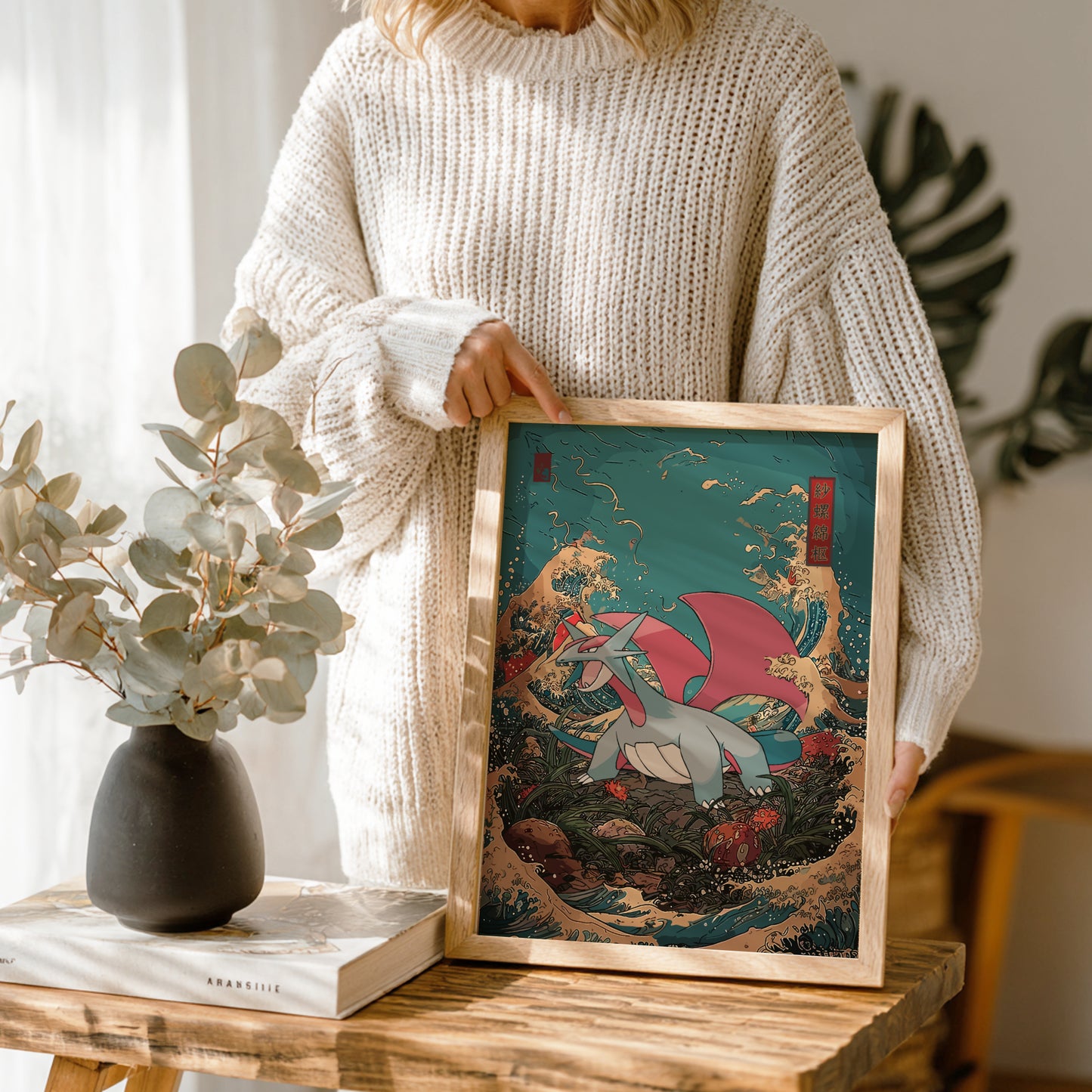 Person holding a framed artwork with Salamence Pokemon in a natural setting
