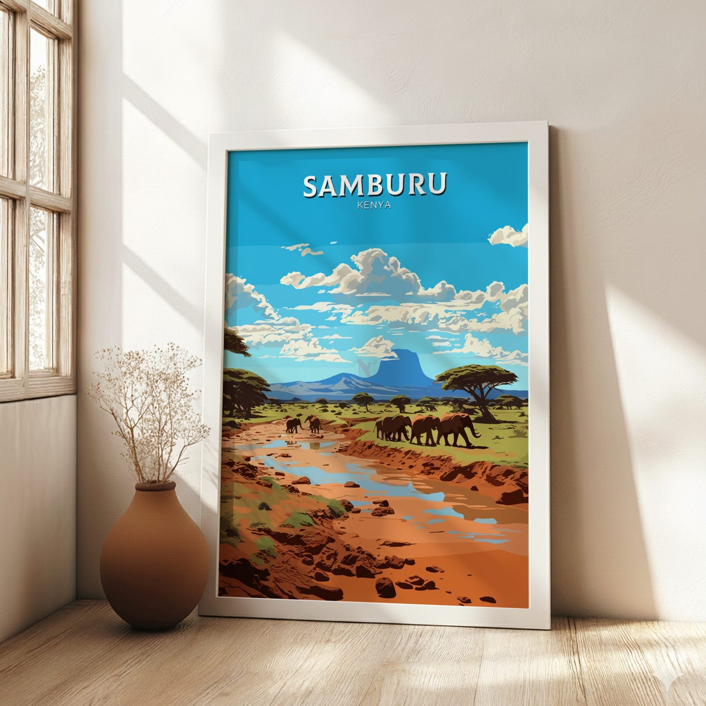 Framed artwork of Samburu Kenya with elephants and landscape, placed on a wooden floor.