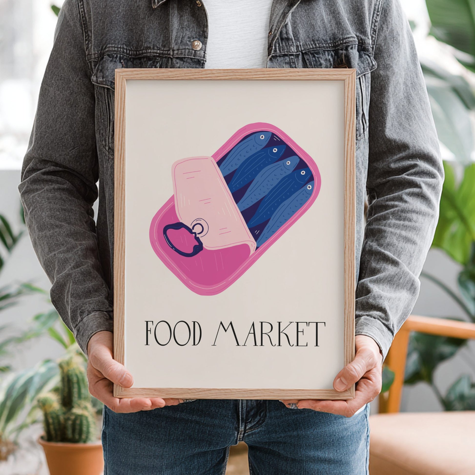 Person holding a framed artwork with 'Food Market' text and abstract design.