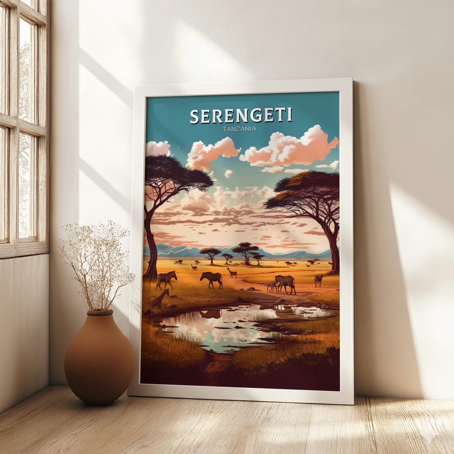Framed artwork of the Serengeti landscape with animals and trees, placed on a wooden floor.