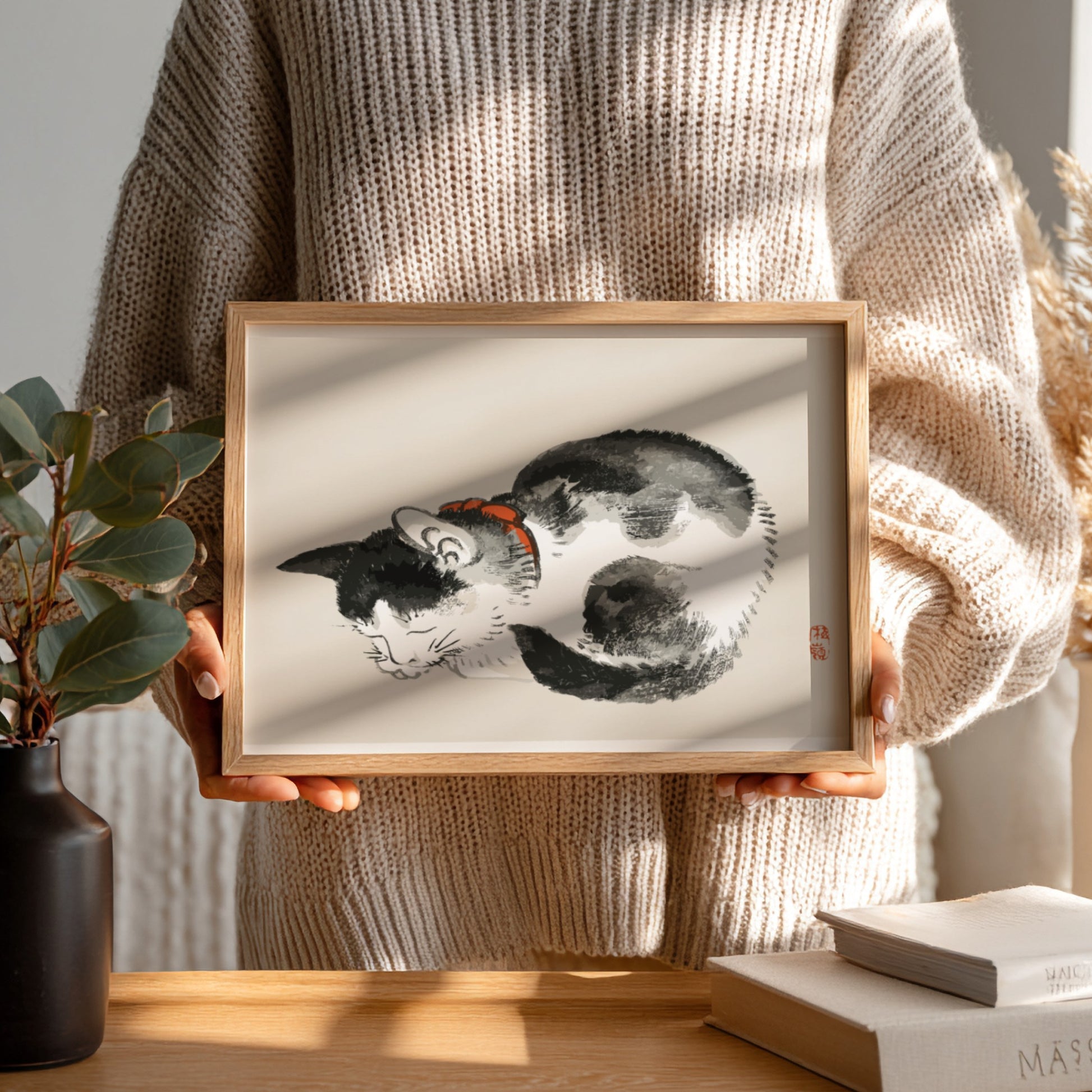 Framed Japanese ink wash drawing of a sleeping black and white cat with a red collar, by Kono Bairei.