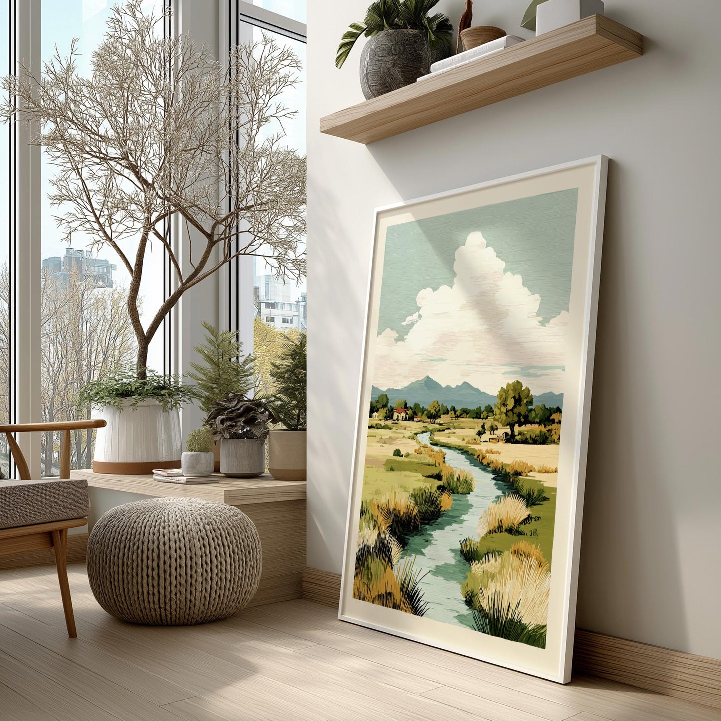 Framed landscape print on a wall in a room with large windows and indoor plants.