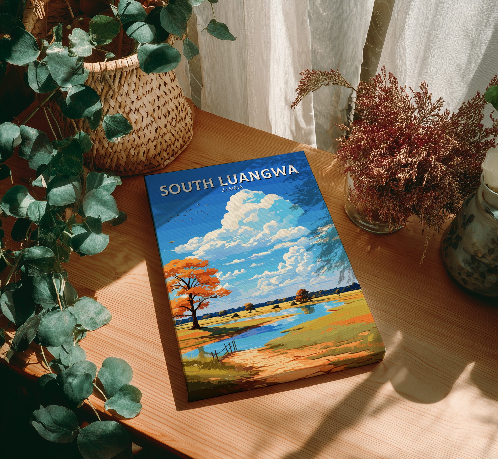 Book titled 'South Luangwa' on a wooden surface with plants around
