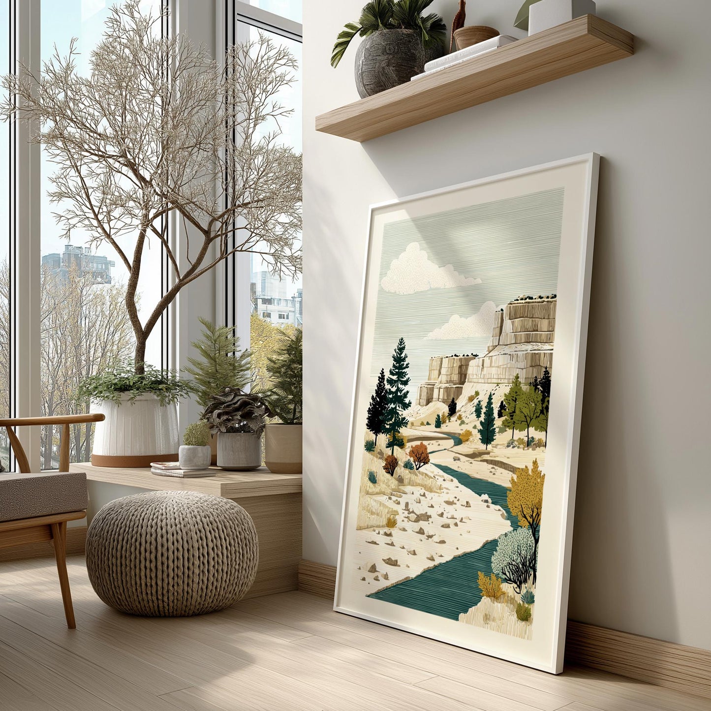 Framed artwork of a landscape with trees and mountains in a modern room with large windows.