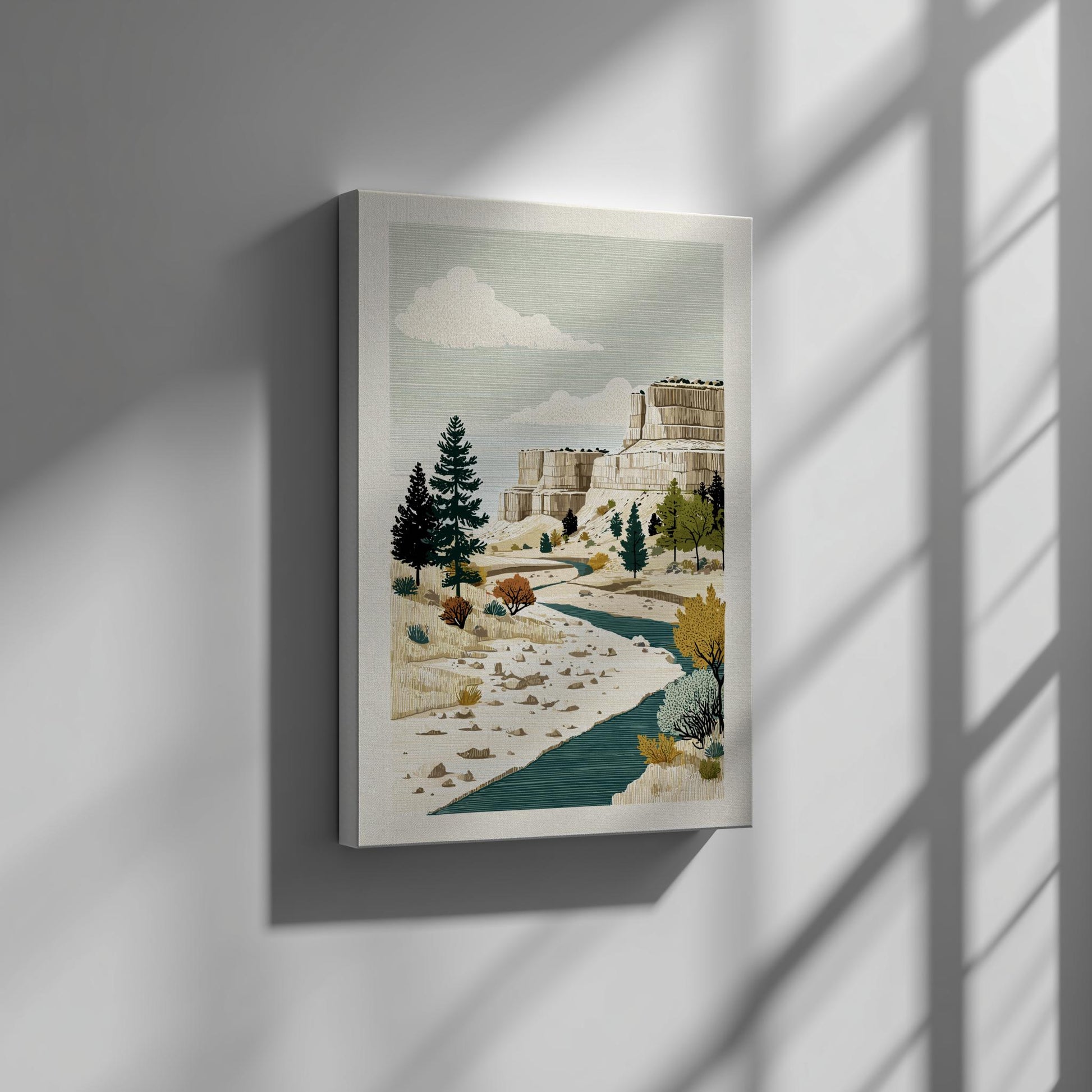 Canvas artwork of a mountain landscape with trees and a river on a gray wall.