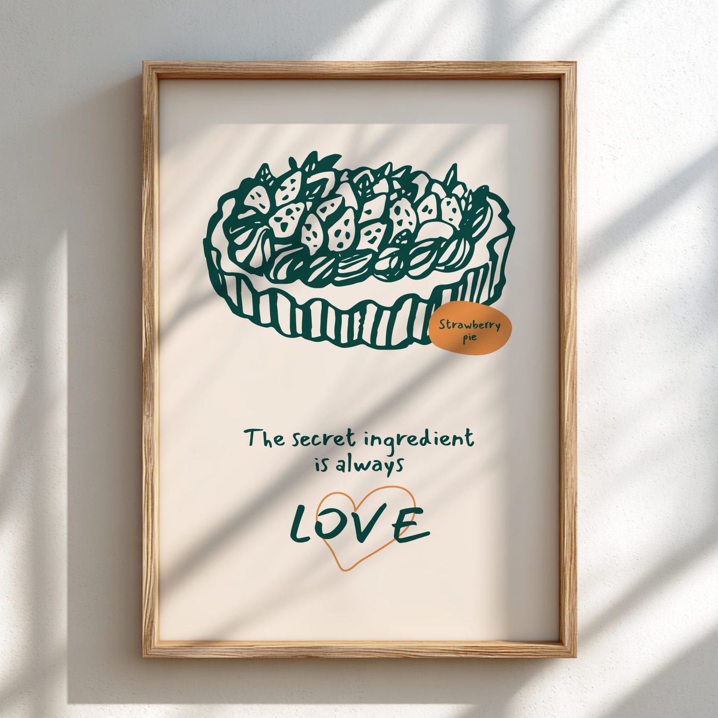Framed artwork of a strawberry tart with text 'The secret ingredient is always love' on a light background.