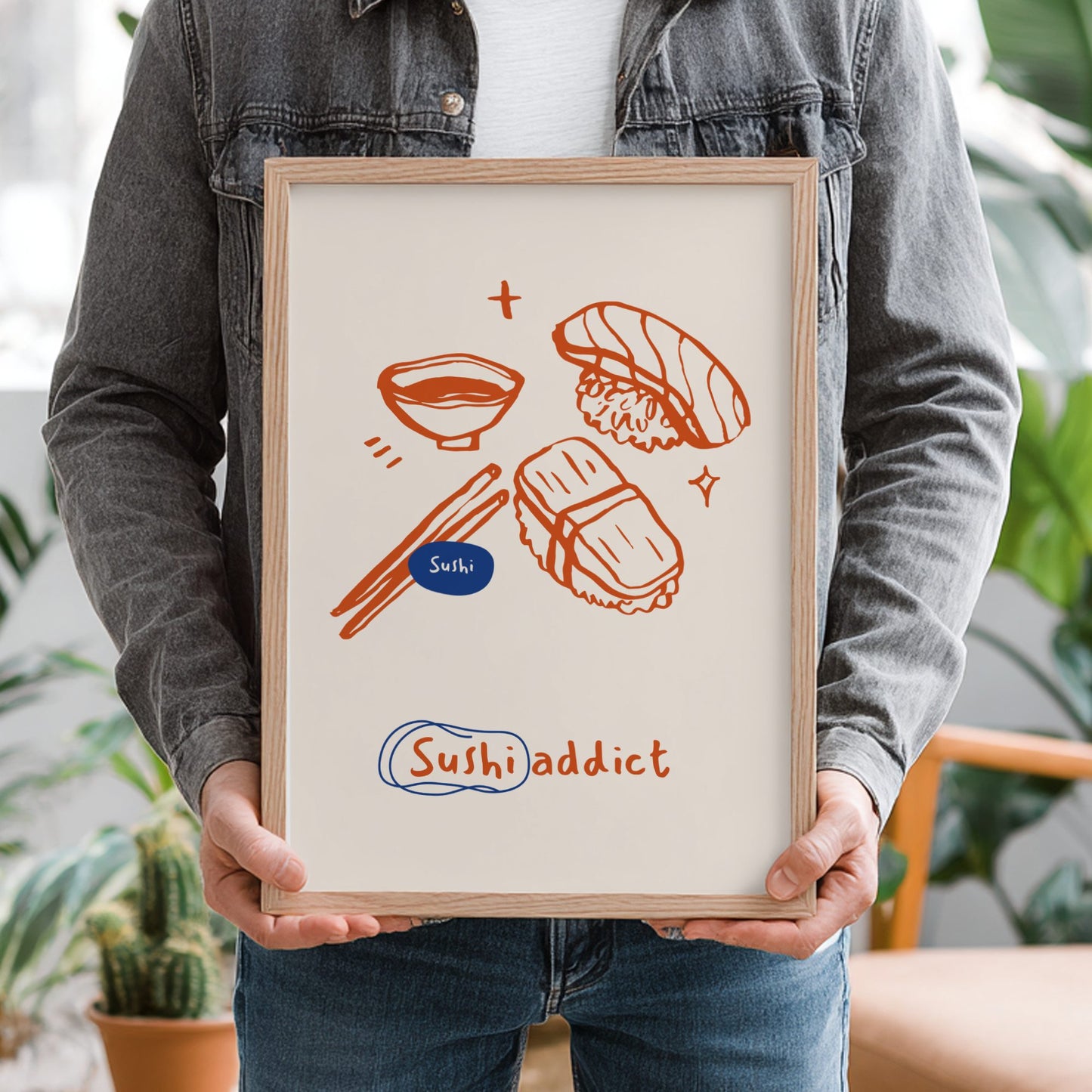 Person holding a framed illustration of sushi with 'Sushi addict' text.