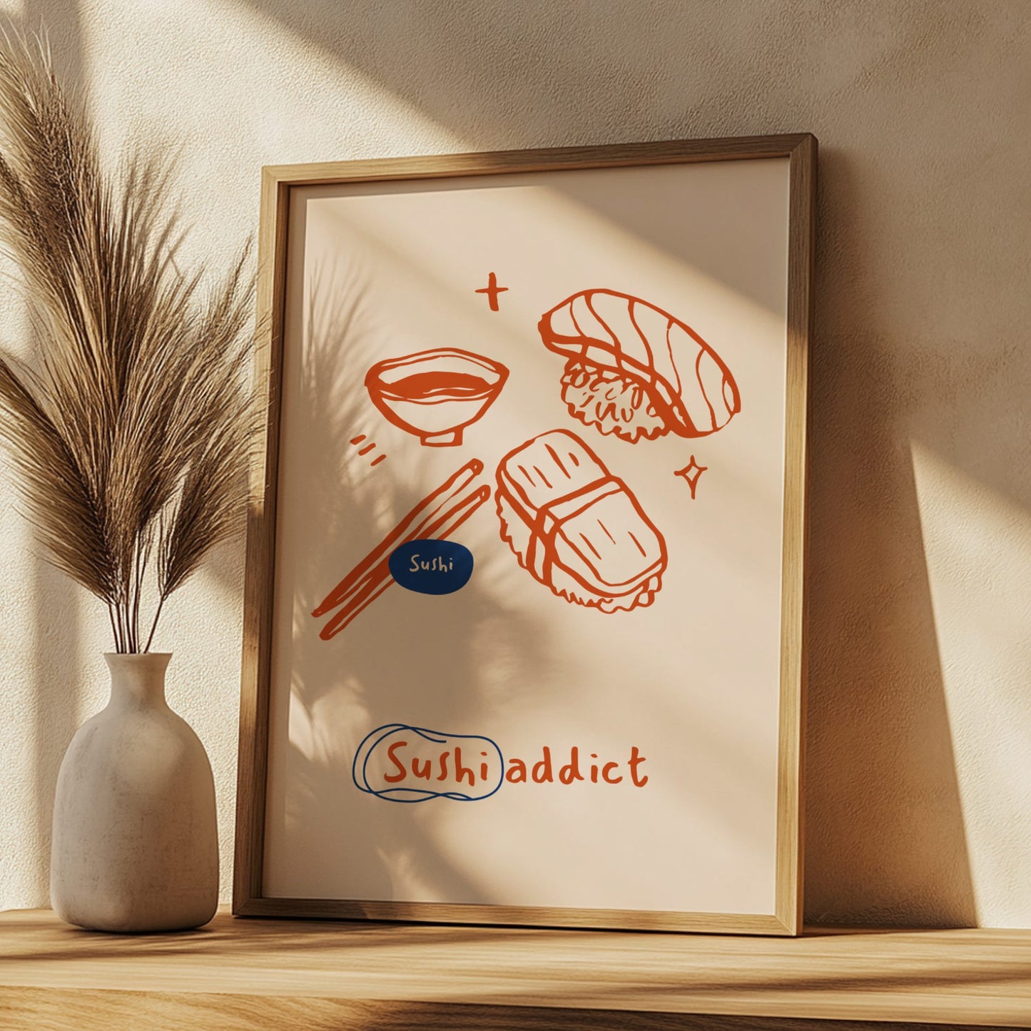 Framed artwork with sushi illustrations on a wall with a vase and plant.