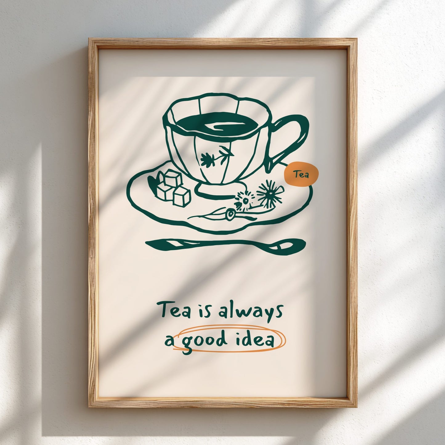 Framed artwork with a teacup illustration and text 'Tea is always a good idea' on a light background.