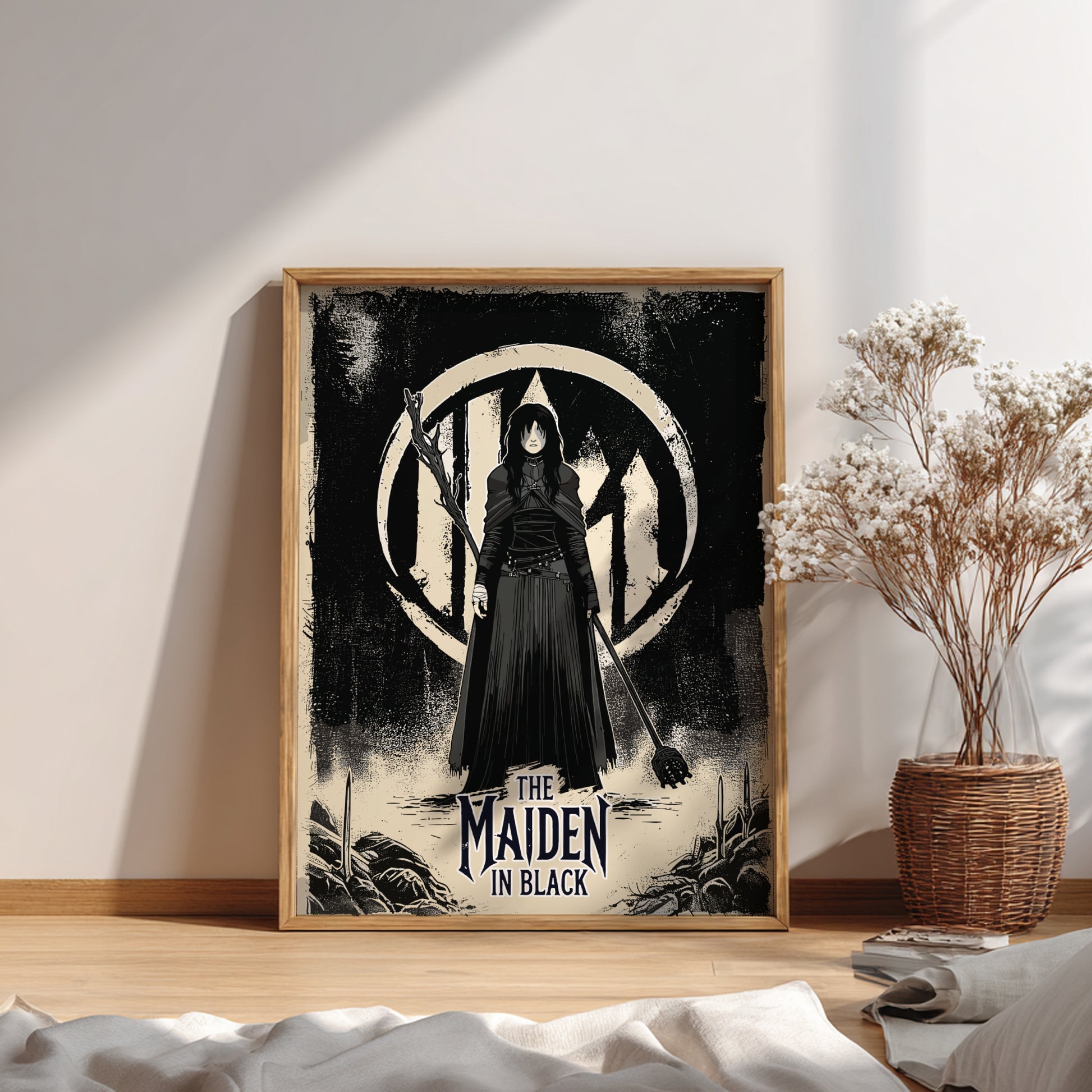 Framed artwork of The Maiden in Black from Dark Souls on a wall with a plant and books below.