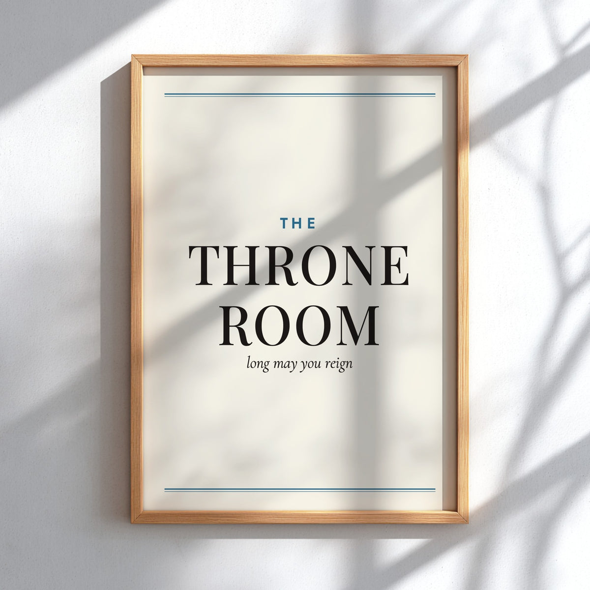 A framed typographic wall art print reading “THE THRONE ROOM” with smaller text “long may you reign,” shown hanging on a light wall with soft shadow overlays.