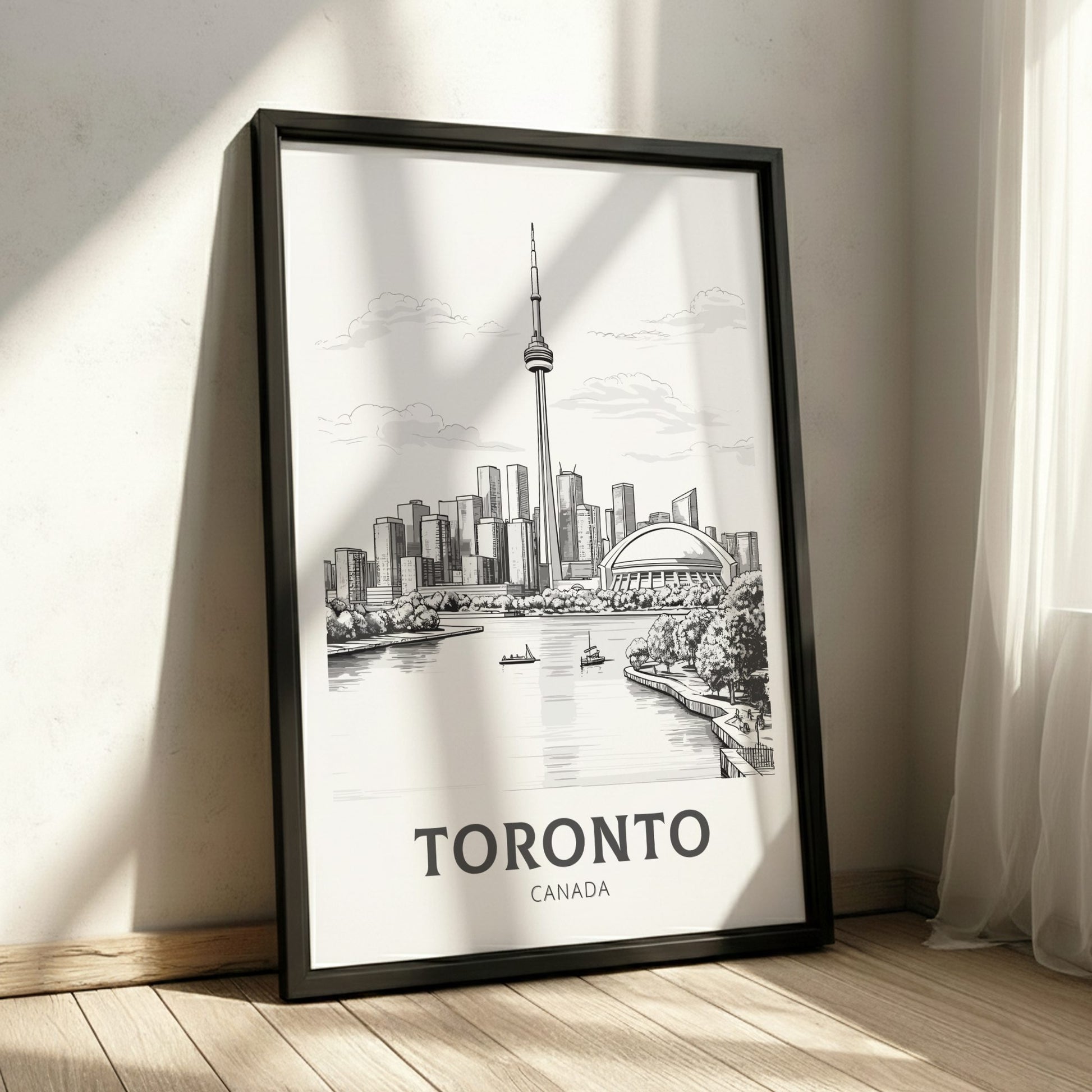 Framed poster of Toronto skyline on a wall with sunlight casting shadows.