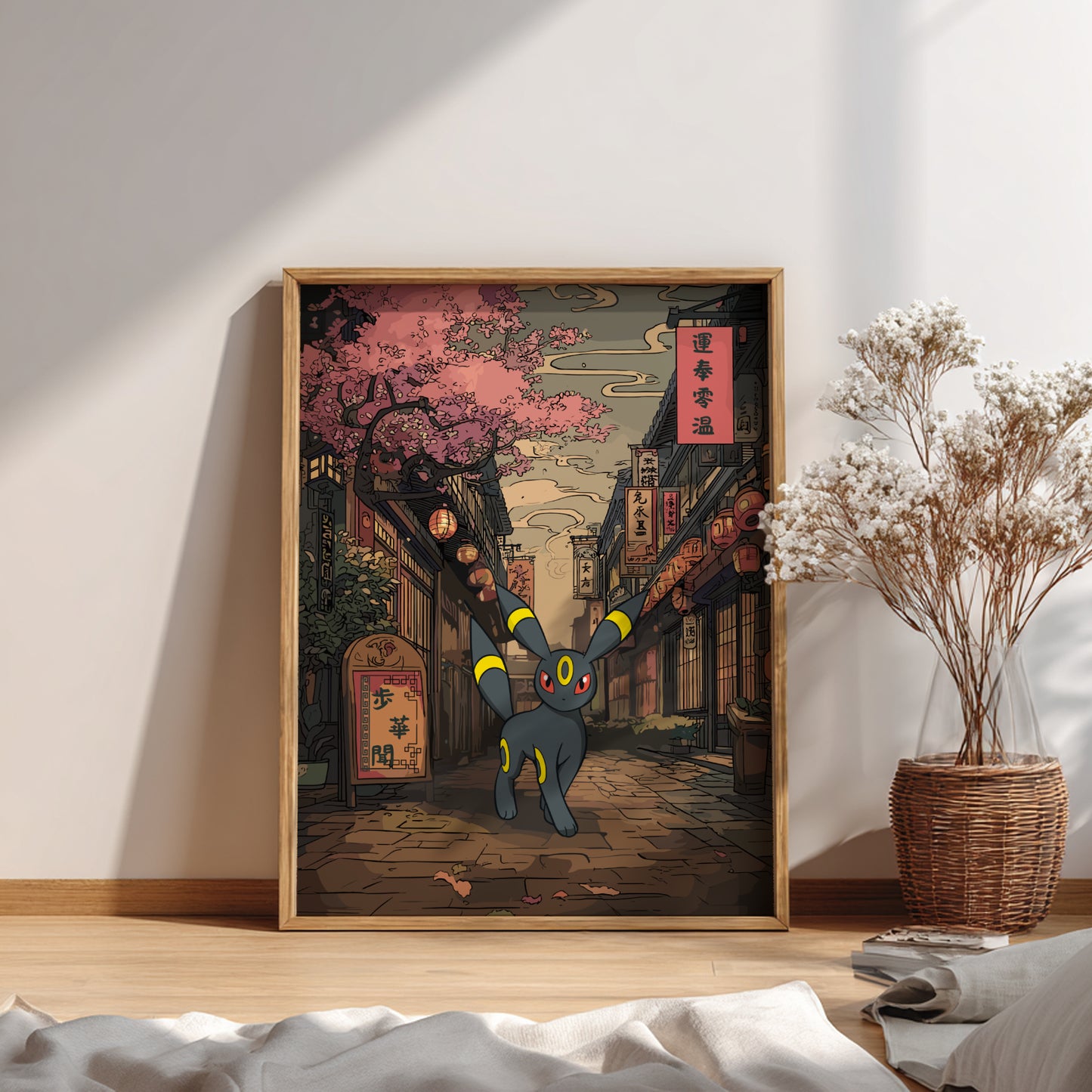 Framed artwork of Umbreon Pokemon in an urban setting with cherry blossoms, on a wall above a bed.