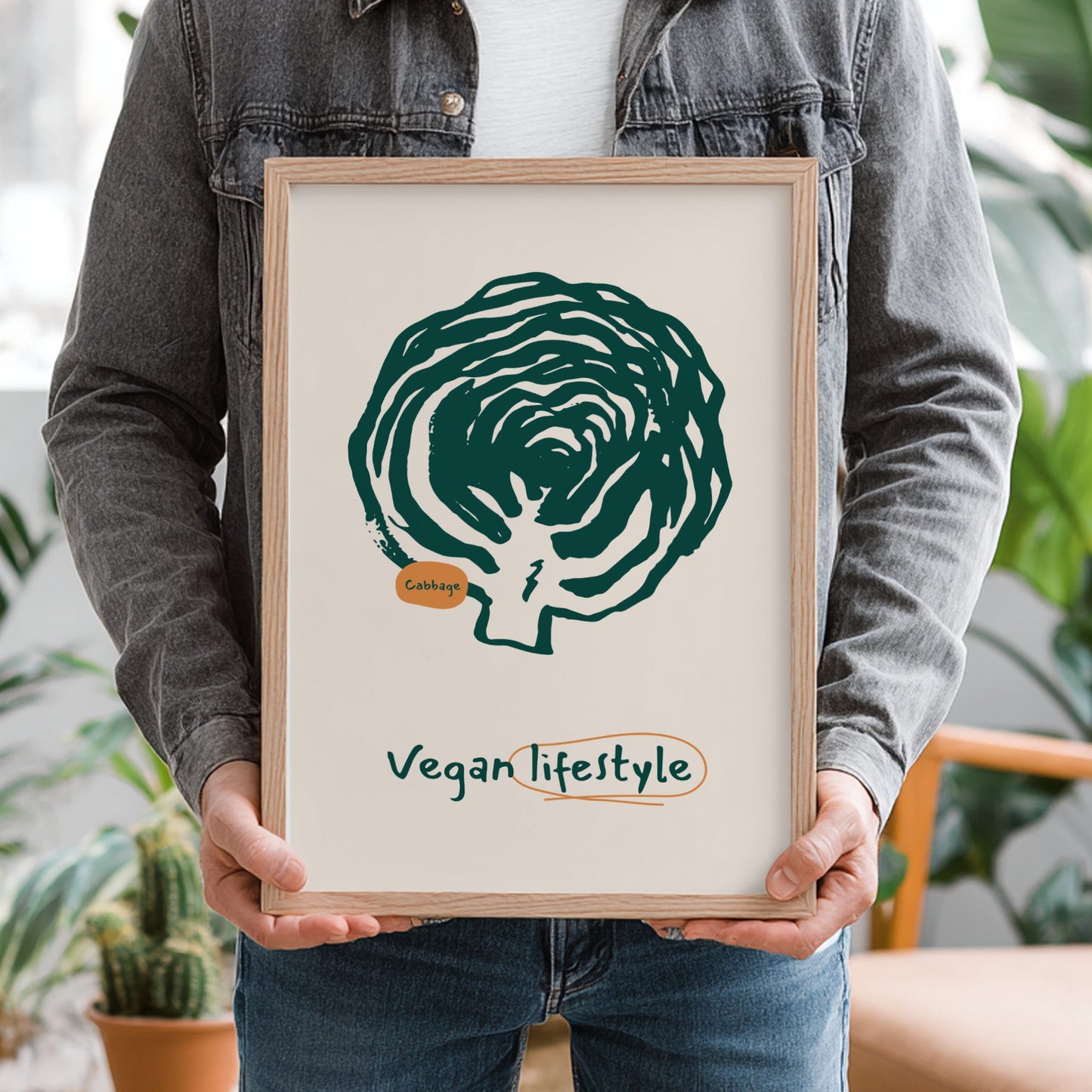Person holding a framed picture with a cabbage illustration and 'Vegan lifestyle' text.