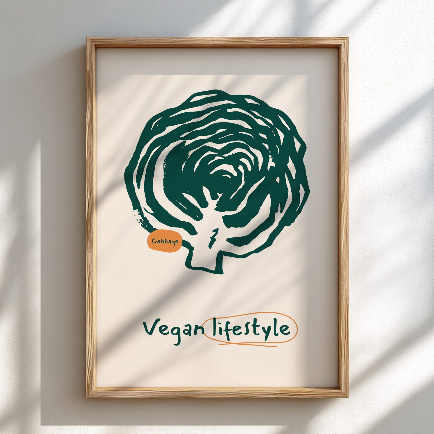 Framed artwork of a green cabbage with 'Vegan Lifestyle' text on a beige background