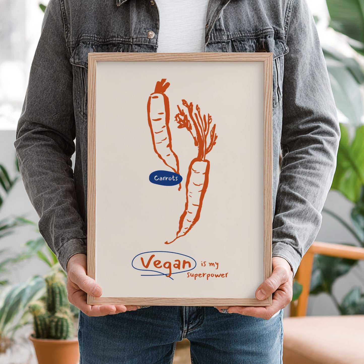 Person holding a framed print with carrots and 'Vegan is my Superpower' text.