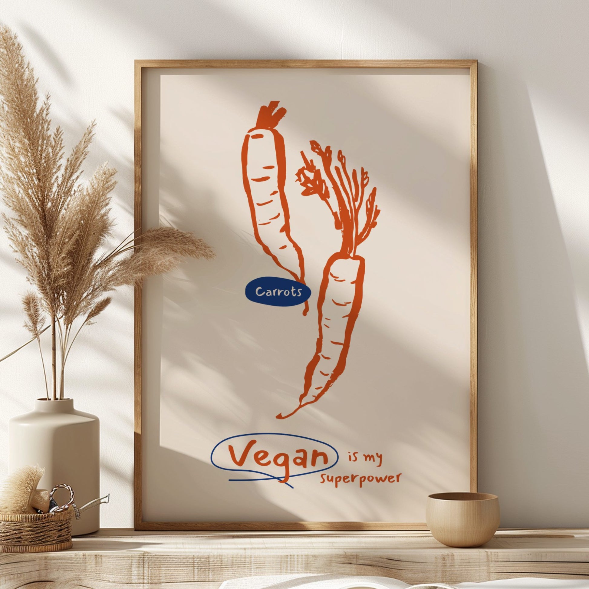 Framed artwork with carrots and 'Vegan is my superpower' text on a wall.