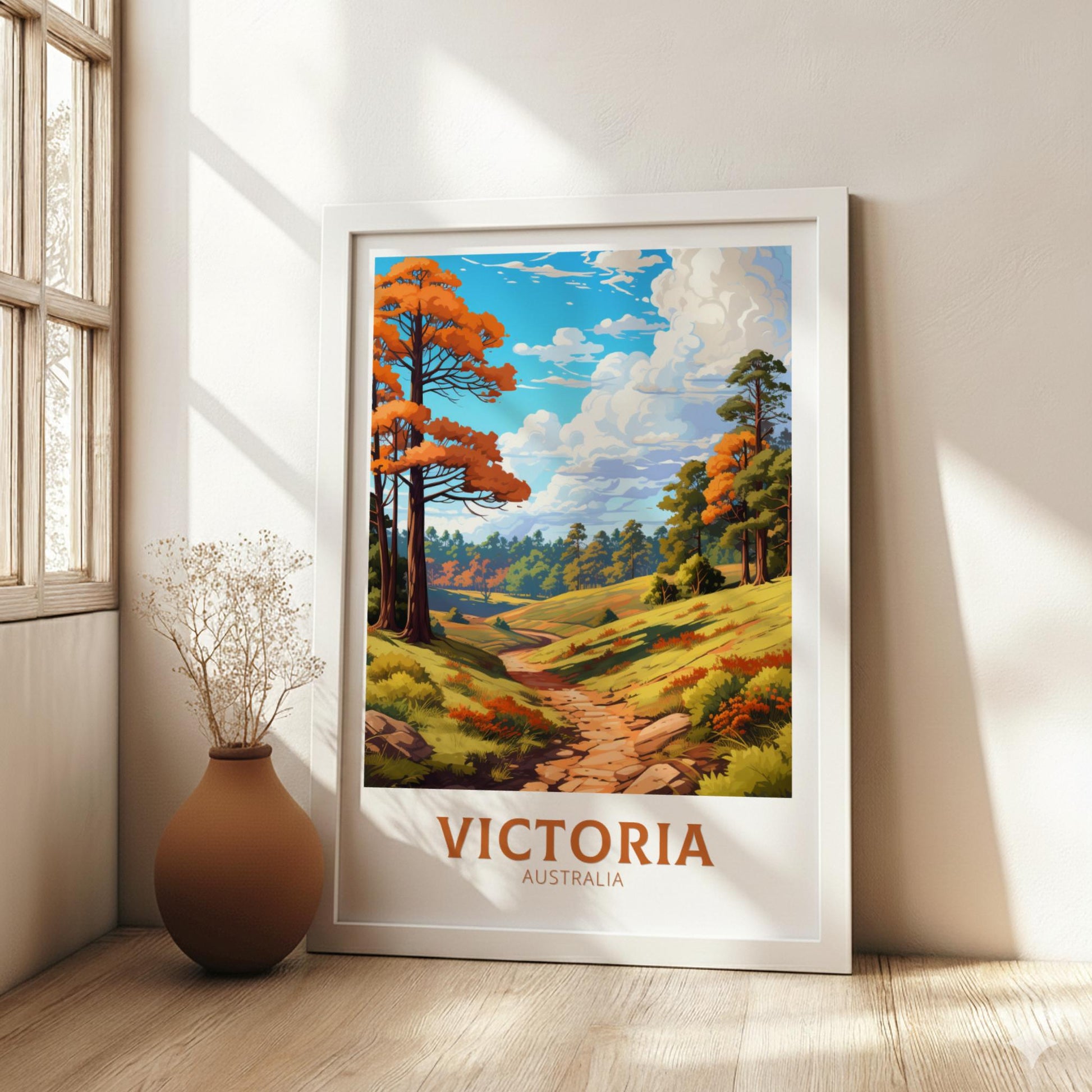 Framed artwork of a scenic landscape with 'Victoria, Australia' text in a room with a vase.